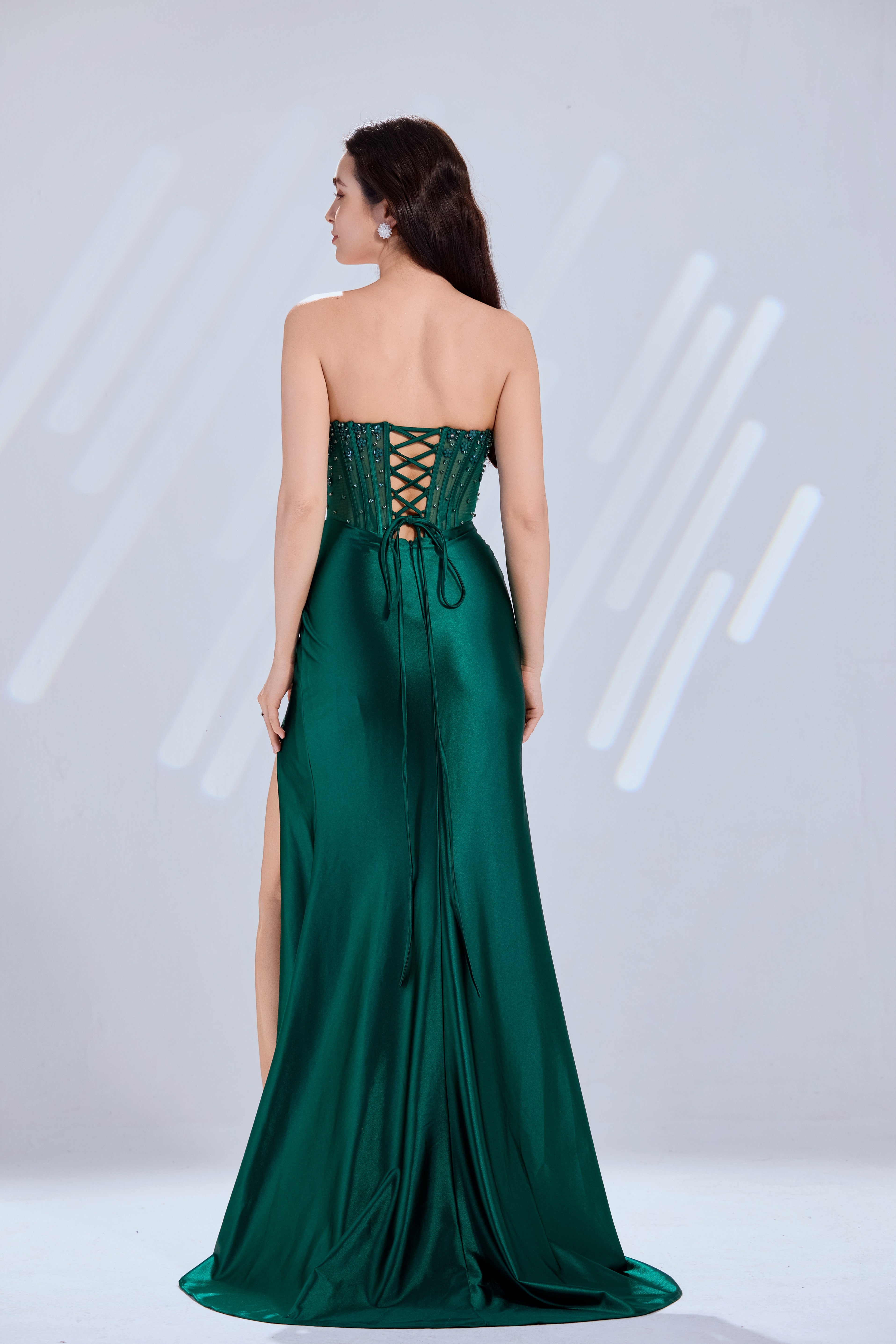 Emerald green prom dress with corset-lace back and high-slit draped skirt