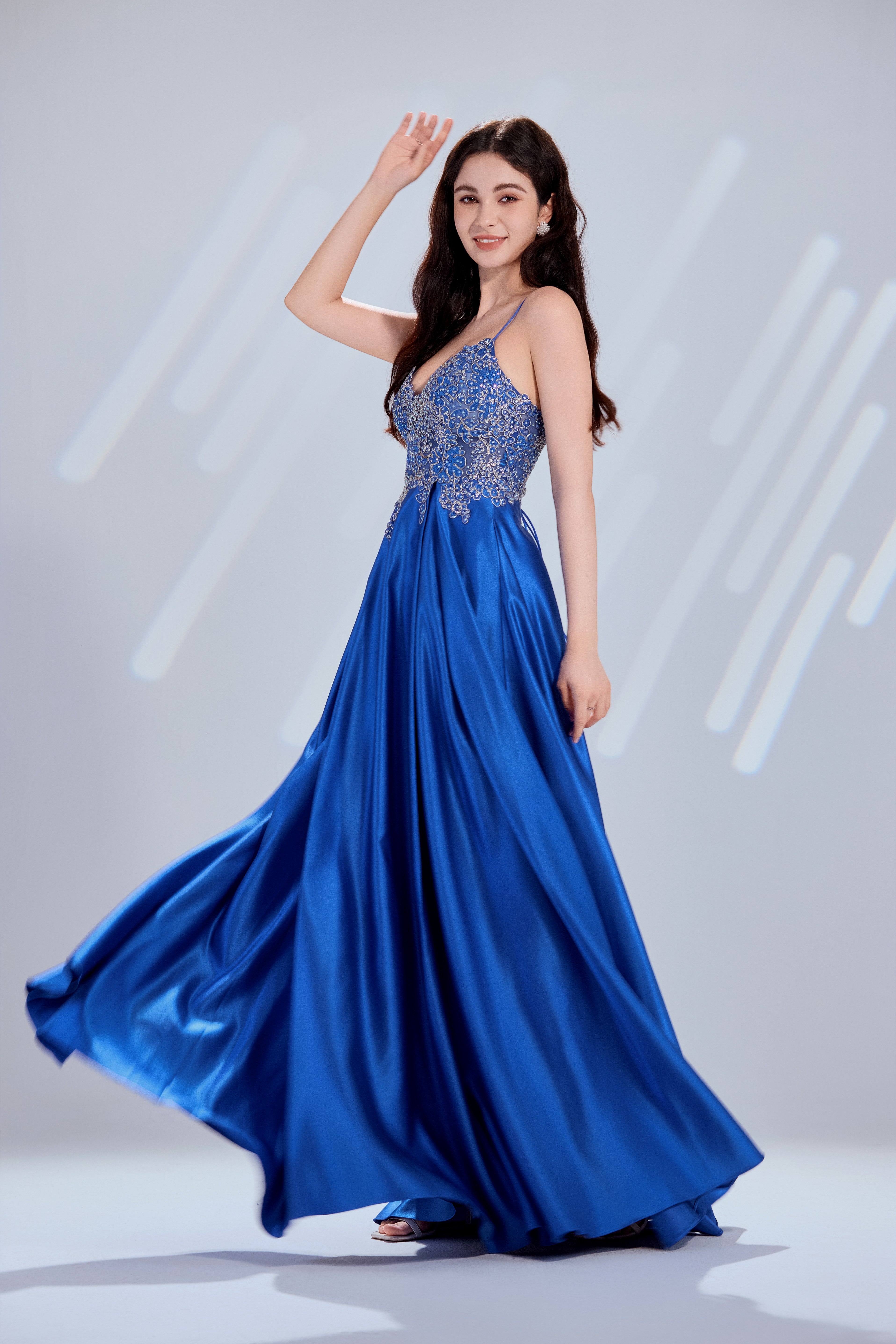 Blue satin A-line prom dress with beaded bodice, thin straps and flared skirt hem