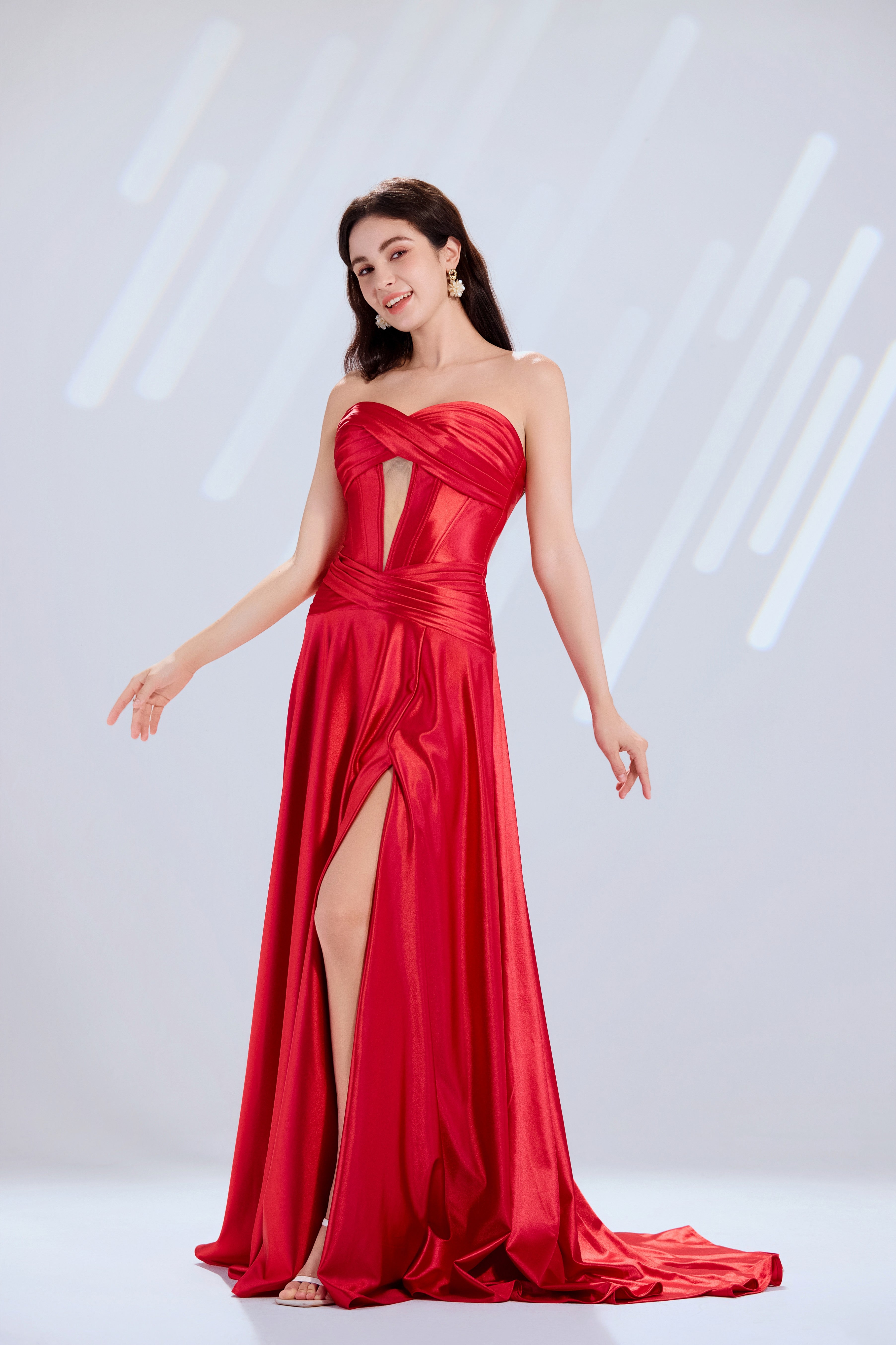 Red strapless satin dress with a front cutout and high slit.