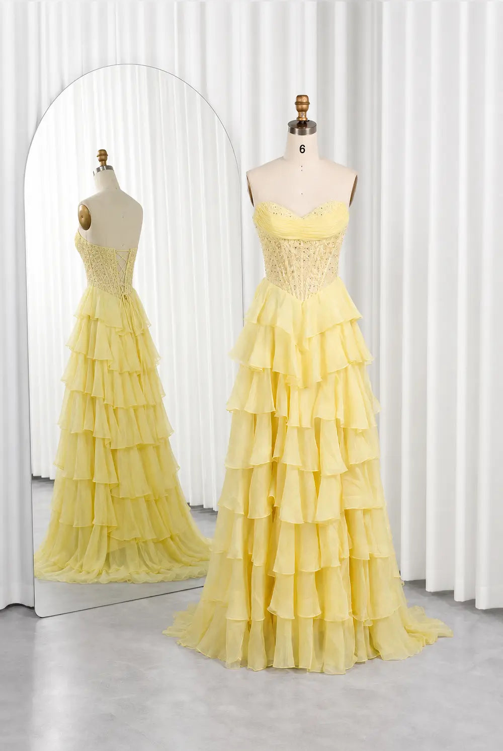 Yellow tiered ruffle strapless dress on mannequin, fitted bodice, long flowing skirt