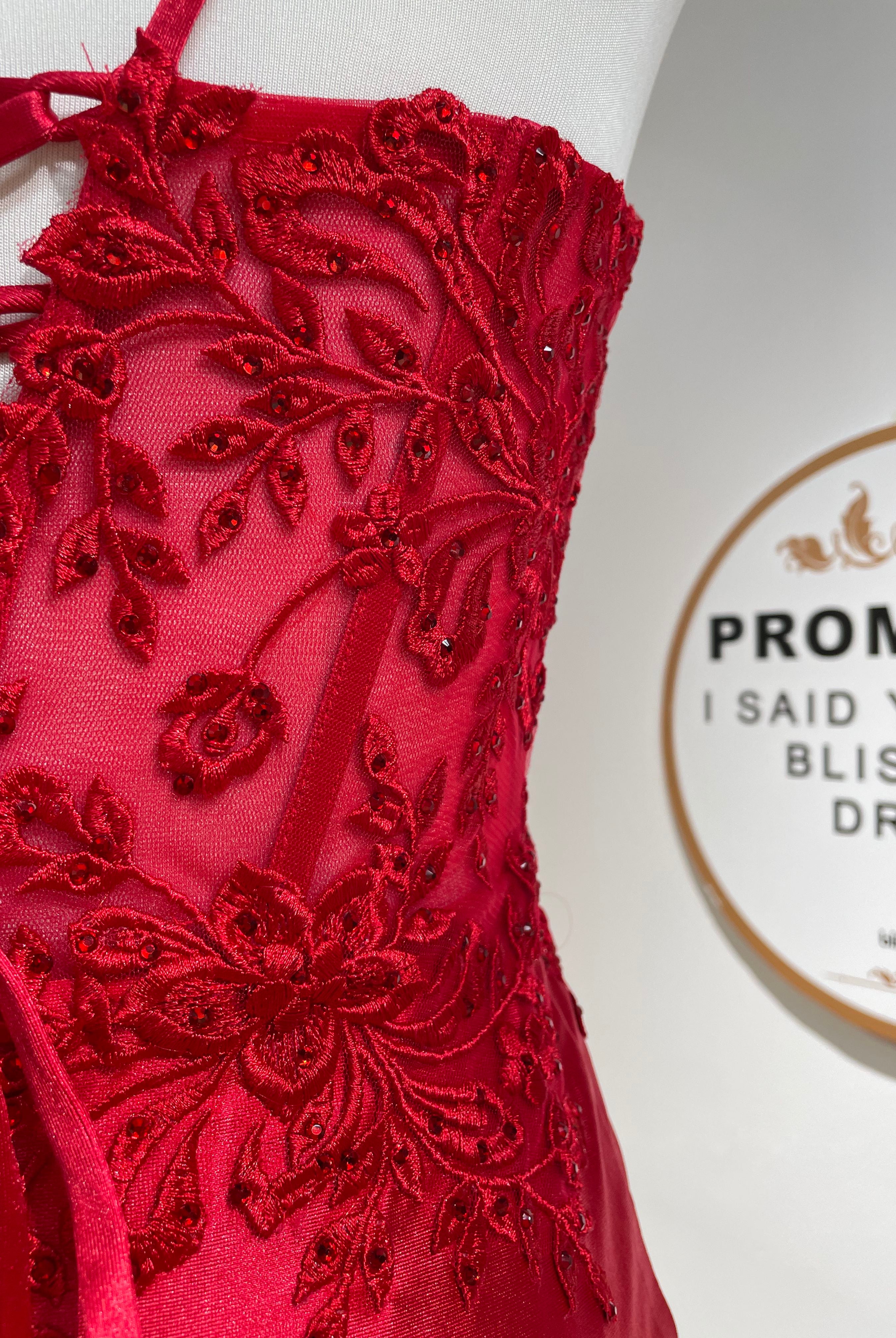 Close-up of red lace corset bodice with beaded floral detailing