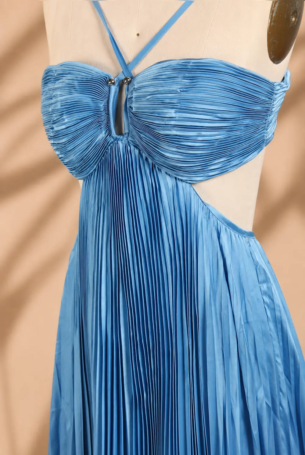 Close-up of blue ruched bust with bow detail and pleated sheer-texture fabric