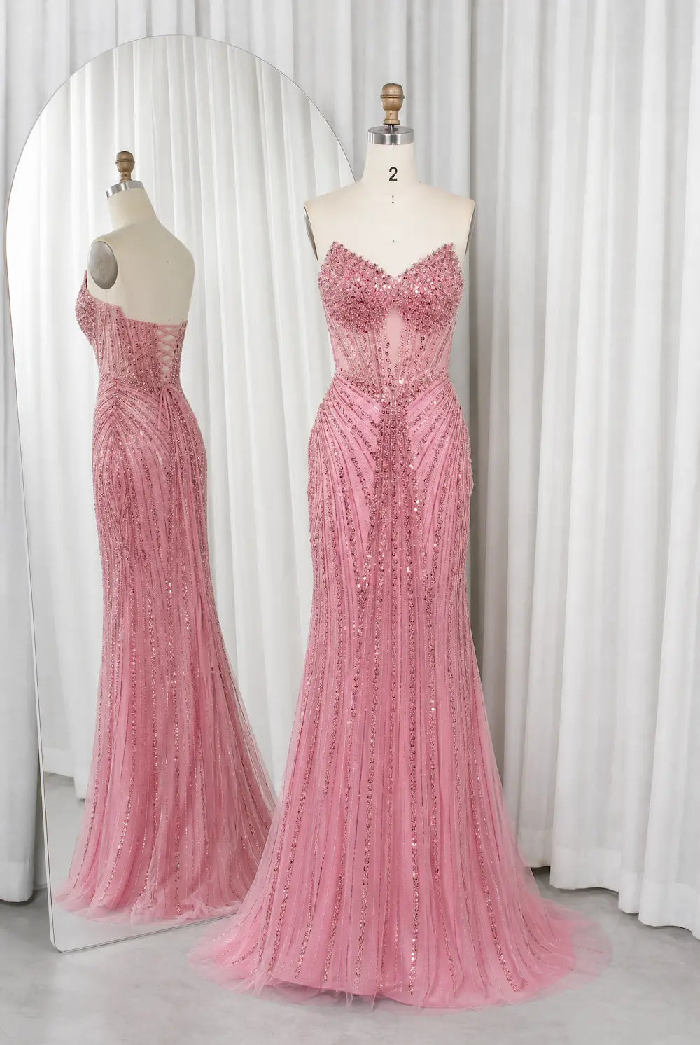 Pink beaded corset mermaid prom dress with sweetheart neckline on mannequin