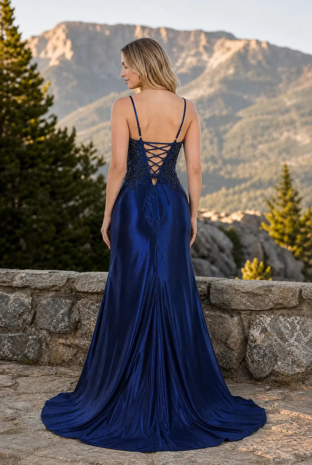 Navy open-back sequin gown with crisscross straps and sweeping satin train