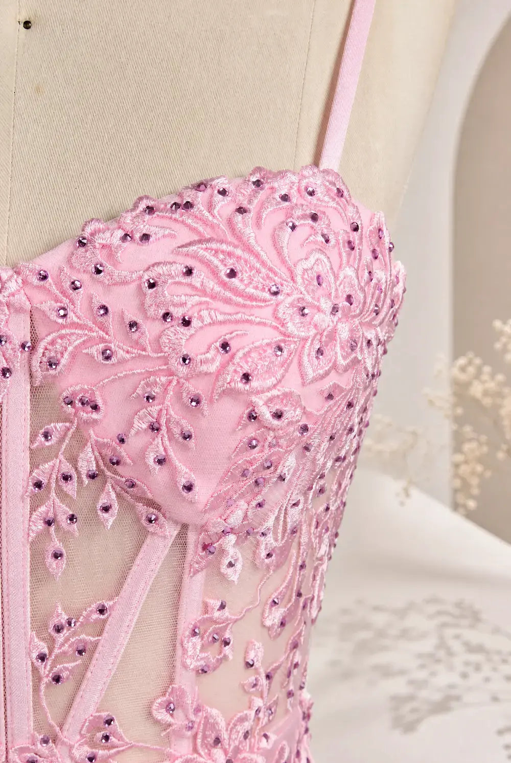 Pink embroidered corset dress bodice close-up with beadwork and appliqués