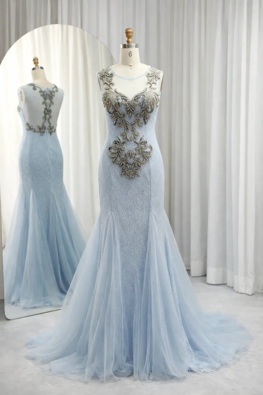 Sky blue lace appliqué illusion neckline gown on mannequin with fitted bodice and tulle skirt