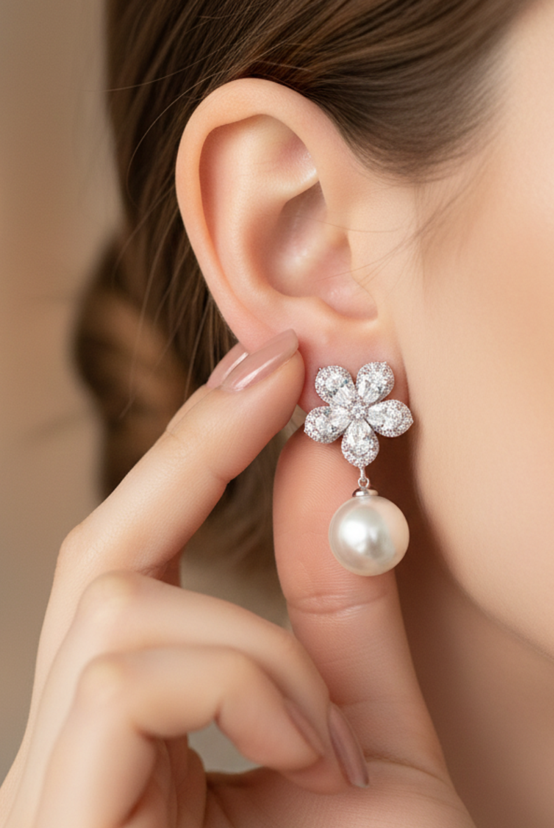 Silver-tone crystal flower pearl drop earrings on ear, with gray pearl dangle