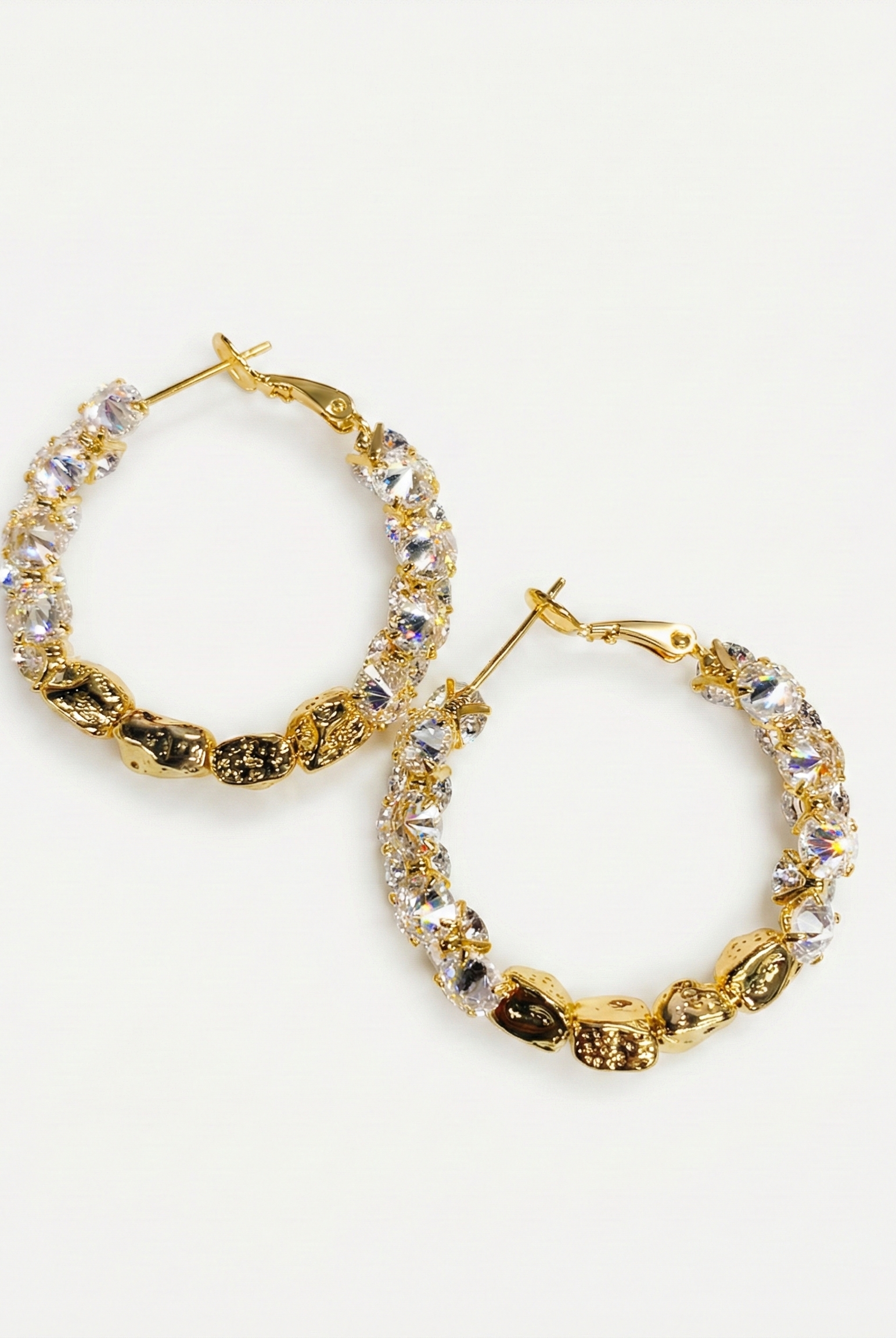 Gold-tone textured hoop earrings with hammered finish and clear crystal accents