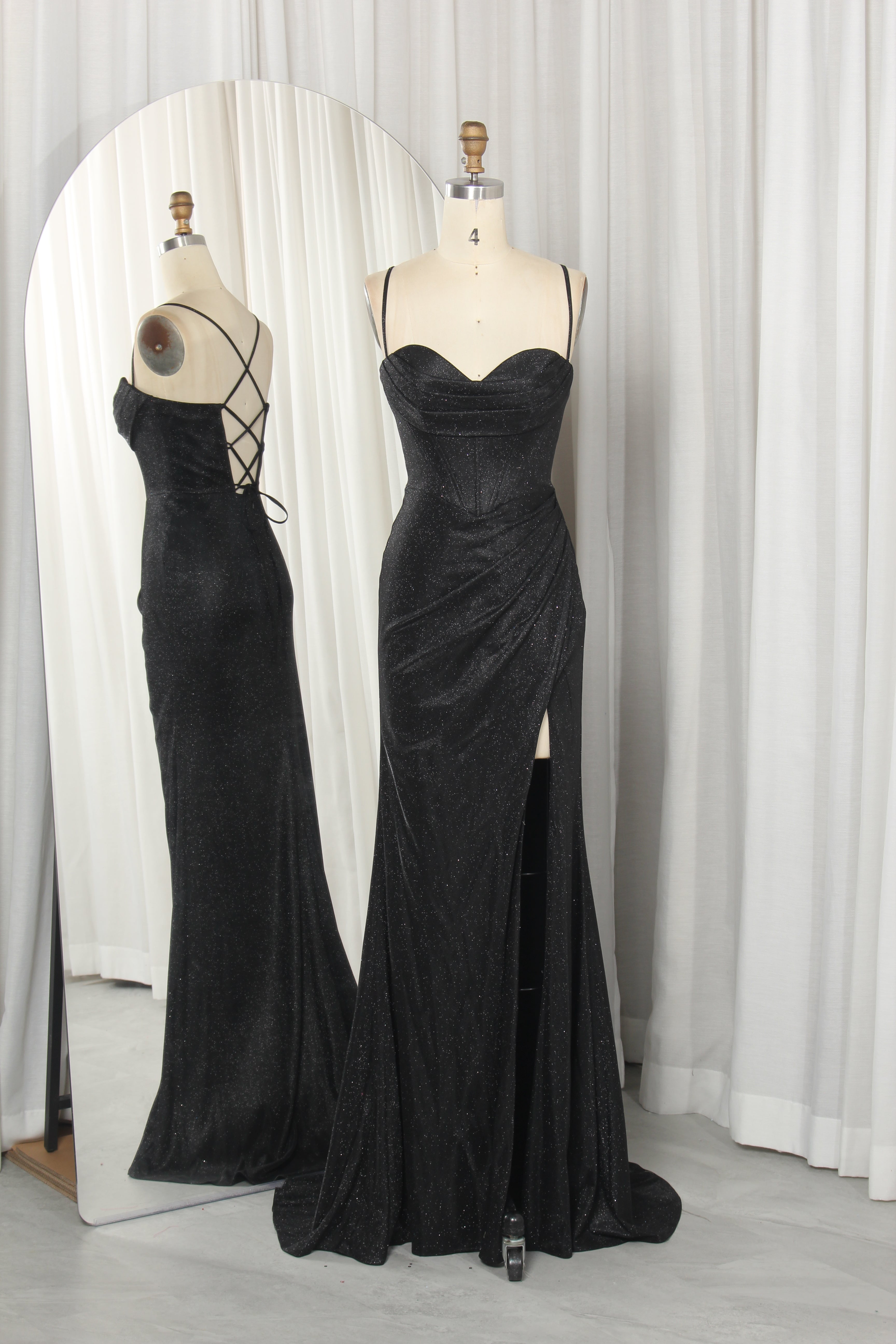 Model wearing a stunning burgundy evening gown with a sequined lace corset bodice, spaghetti straps, and a draped satin skirt featuring a high leg slit.