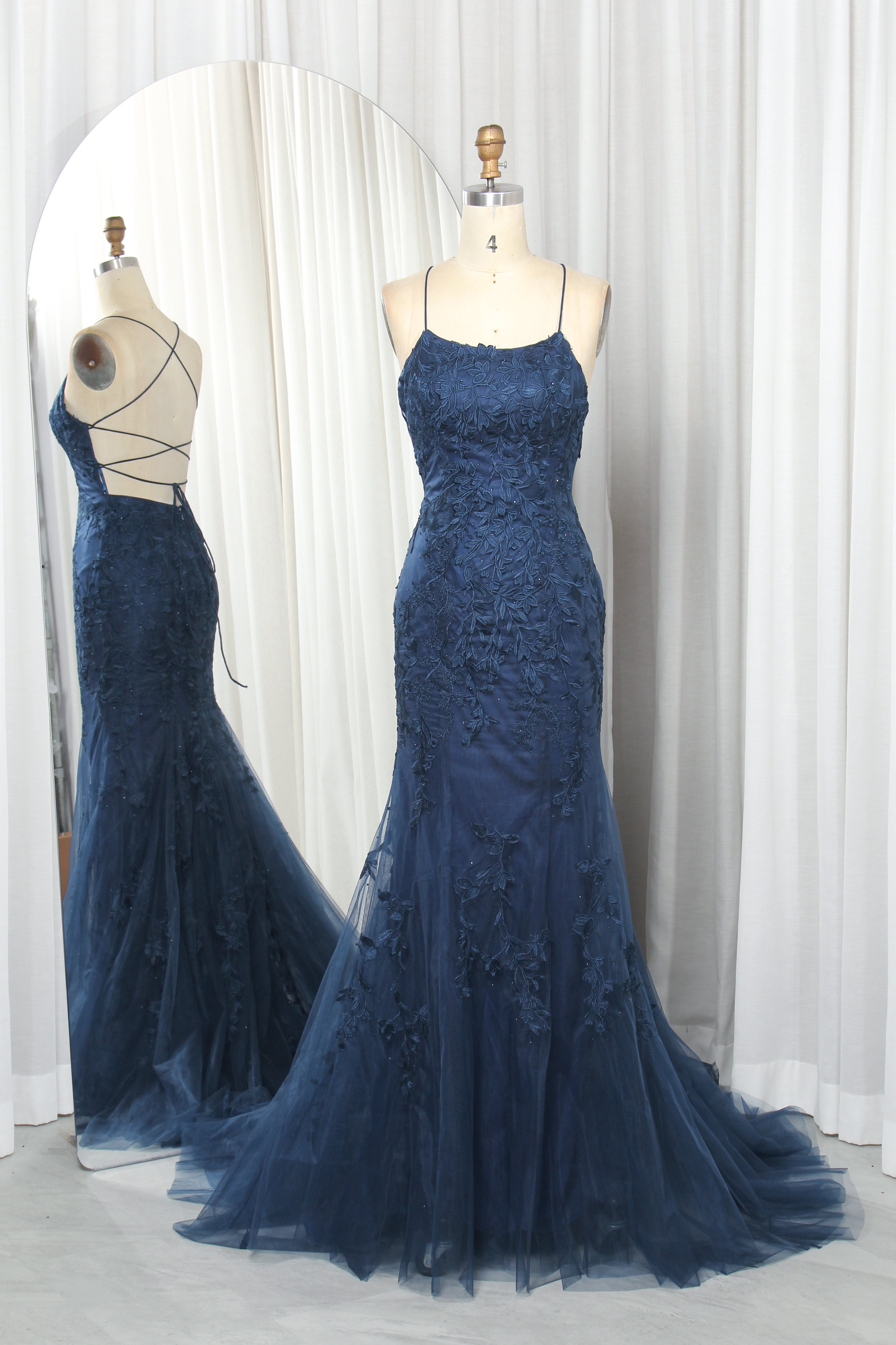 Navy floral lace tulle mermaid prom gown on mannequin with spaghetti straps