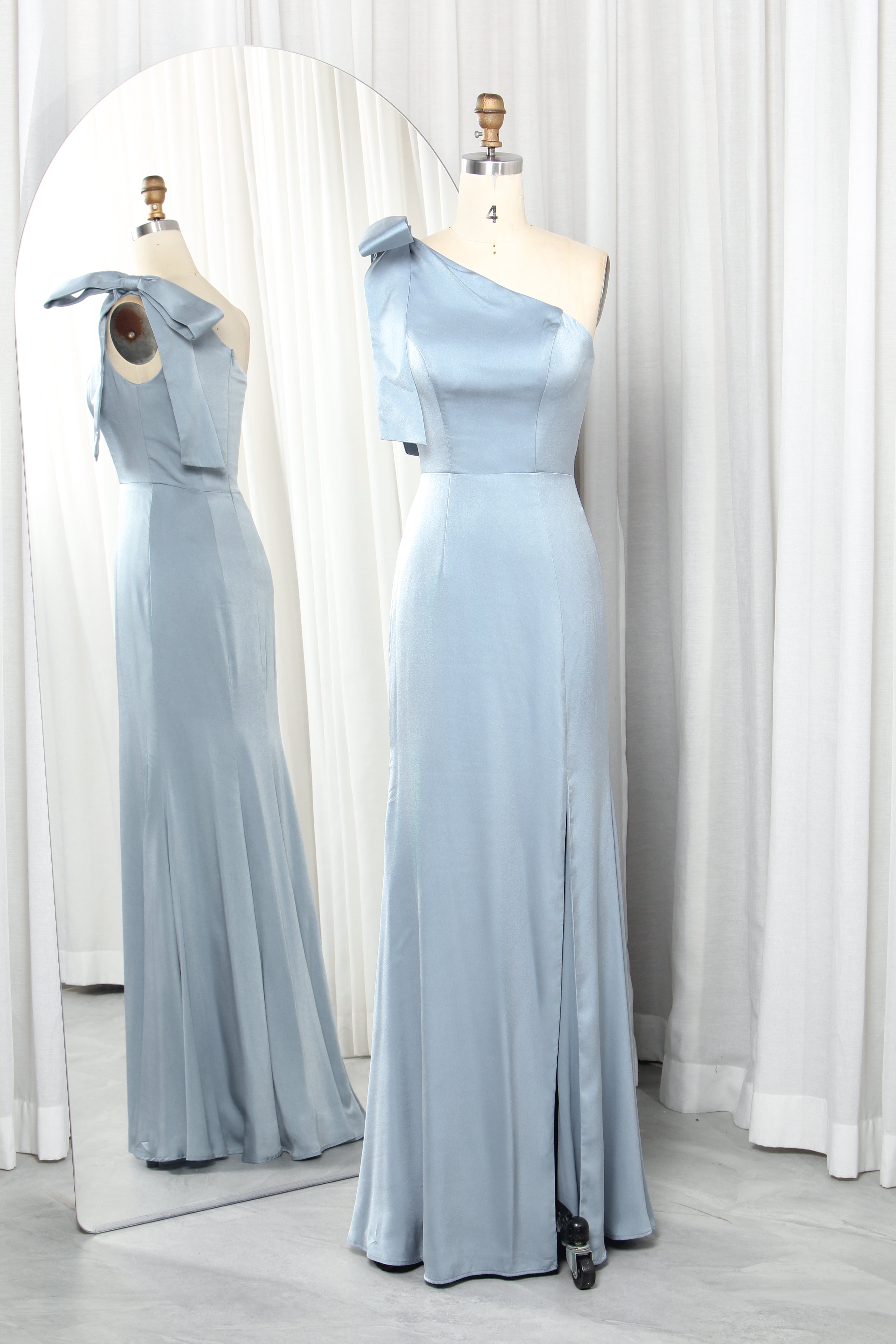 Dusty blue one-shoulder satin dress with bow.