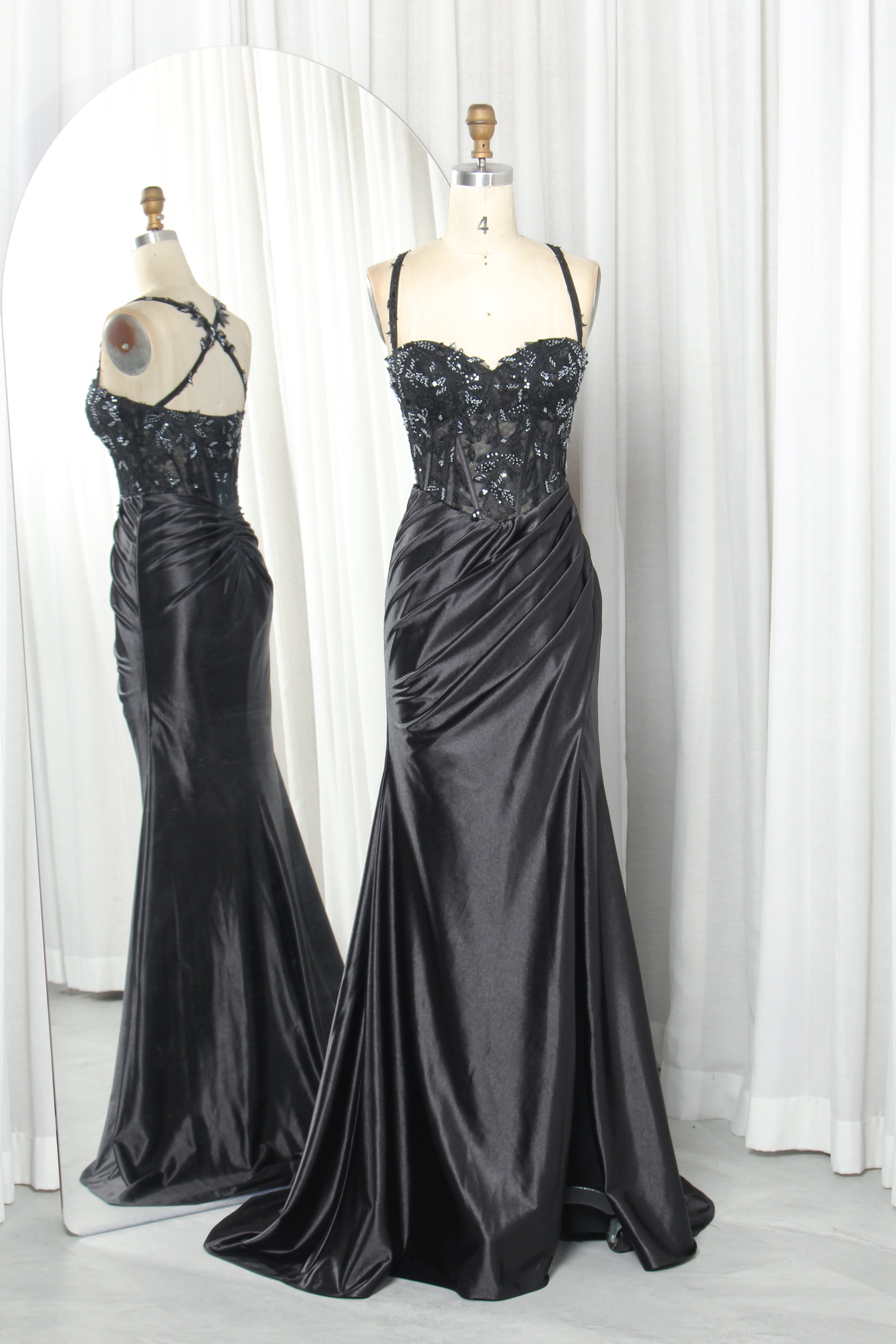 Black mermaid gown on mannequin with beaded lace corset bodice and satin slit skirt