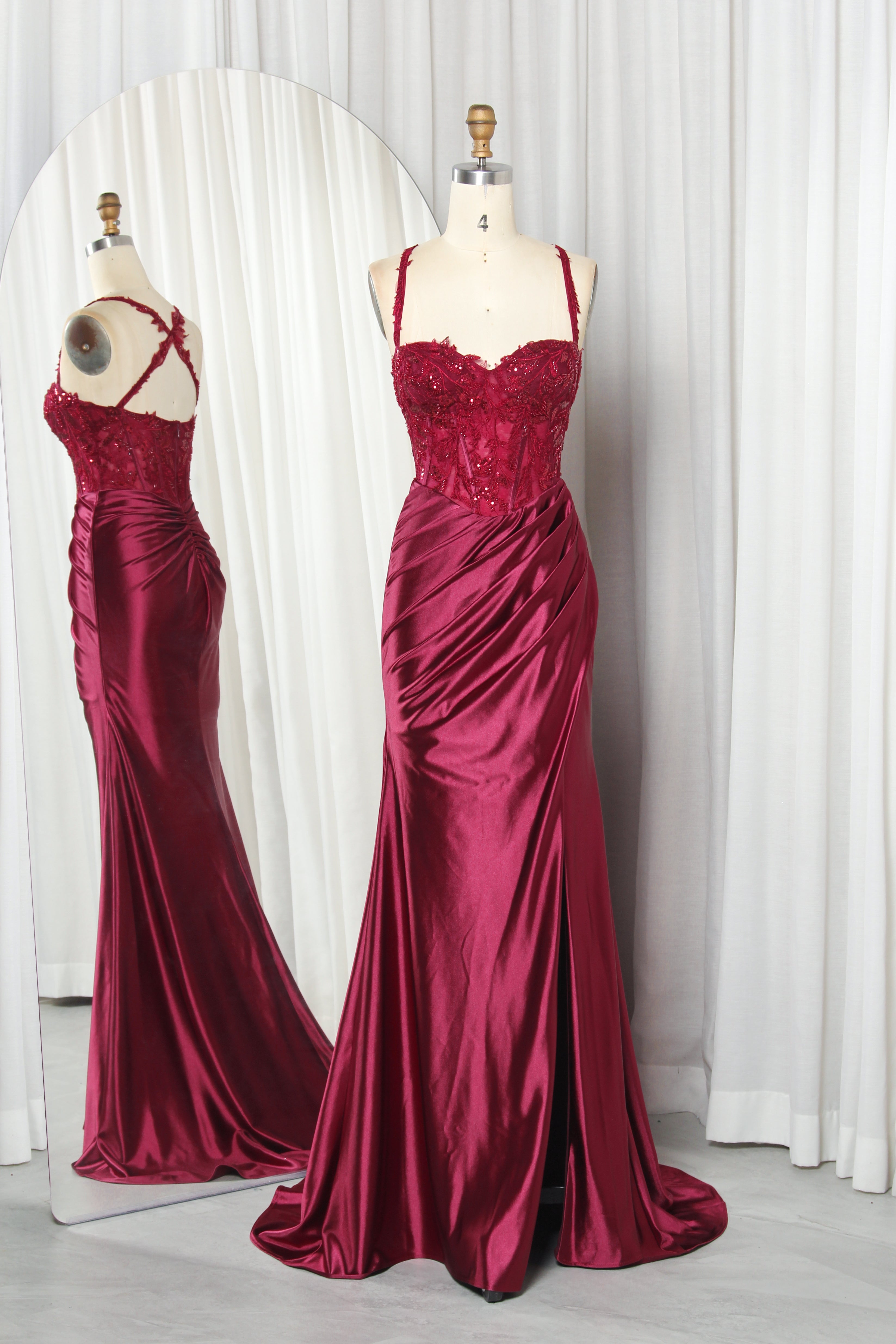 Wine mermaid gown on mannequin with beaded lace corset bodice and satin slit skirt