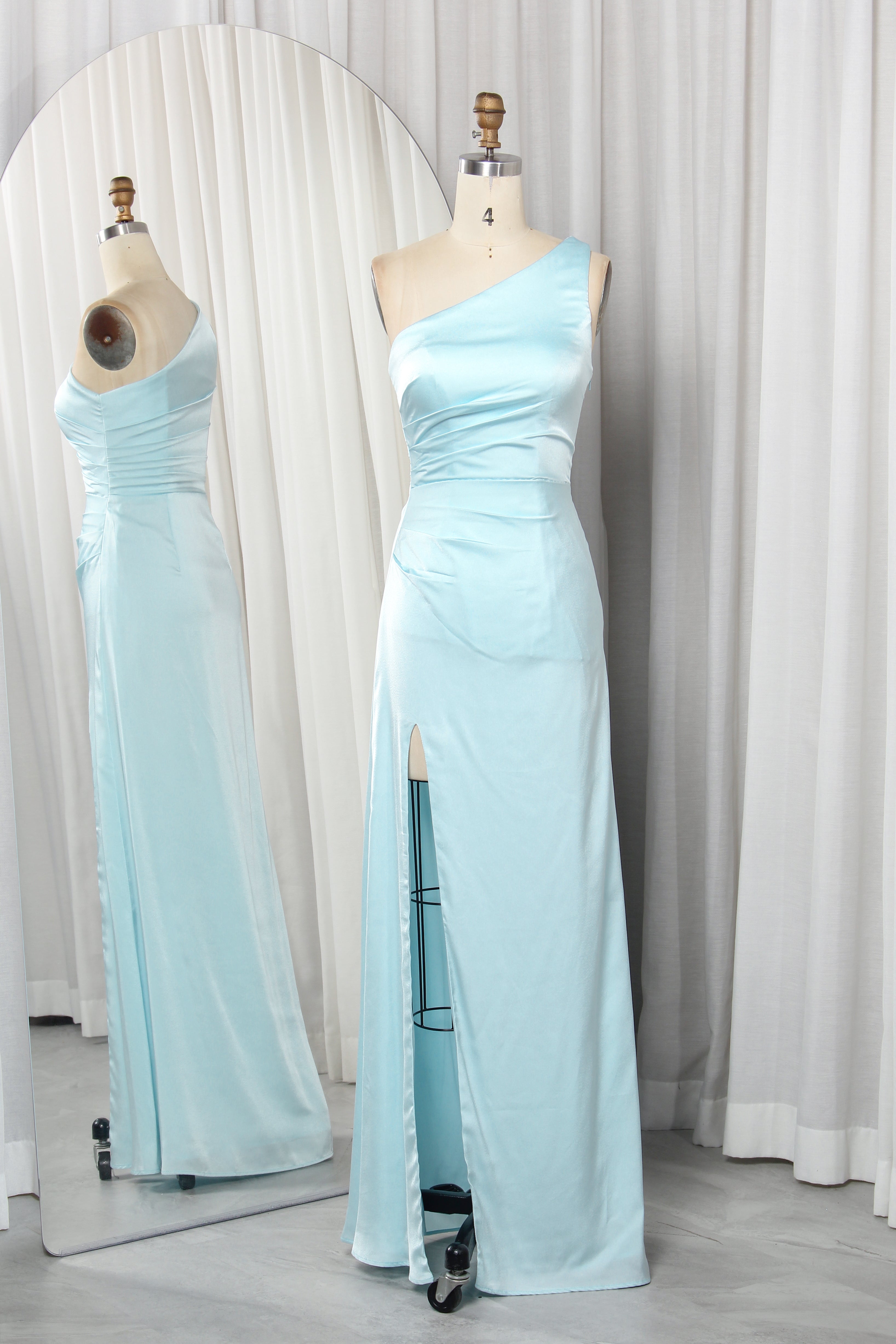 one-shoulder dress with a high slit displayed on a mannequin.