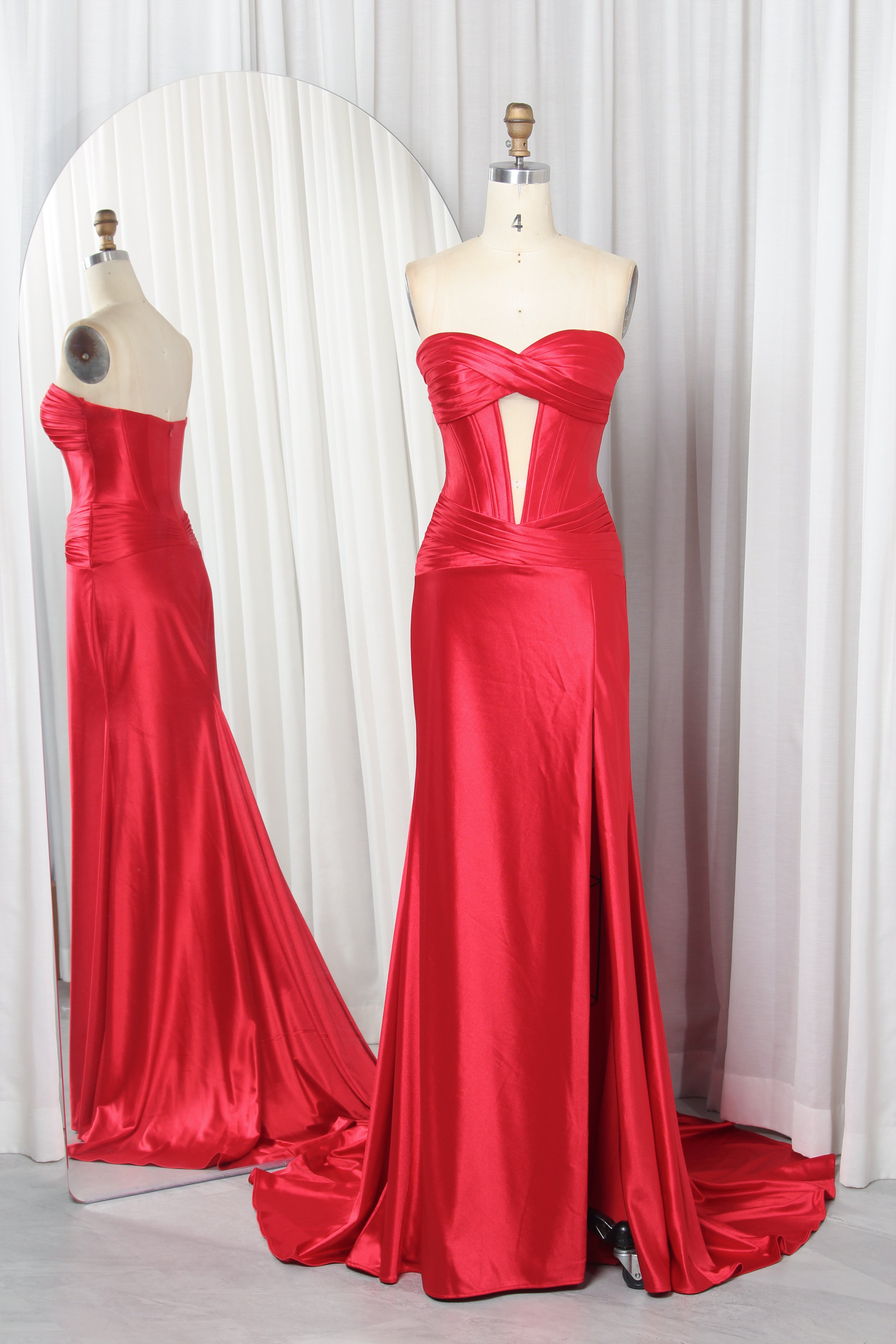 Red satin strapless corset mermaid gown on mannequin with crossed neckline keyhole