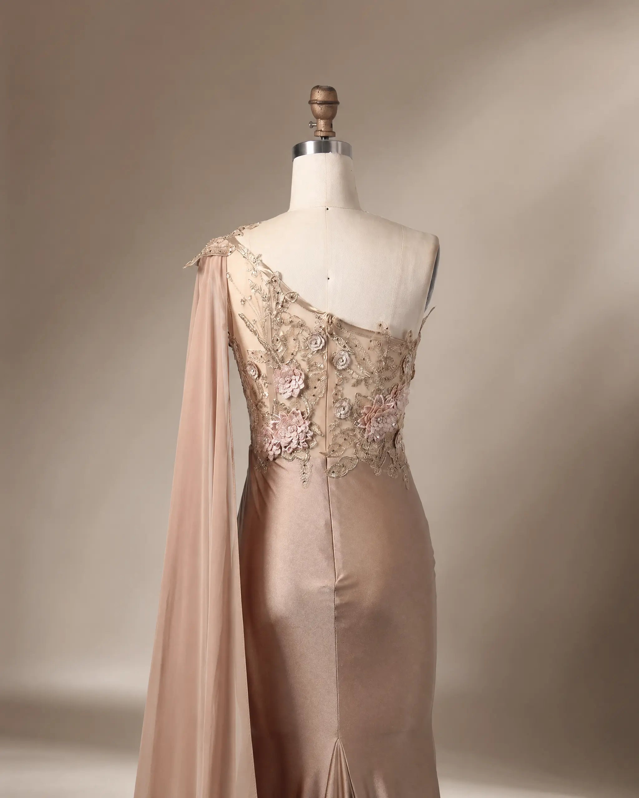 Champagne satin one-shoulder gown with 3D floral appliqués and long draped sleeve