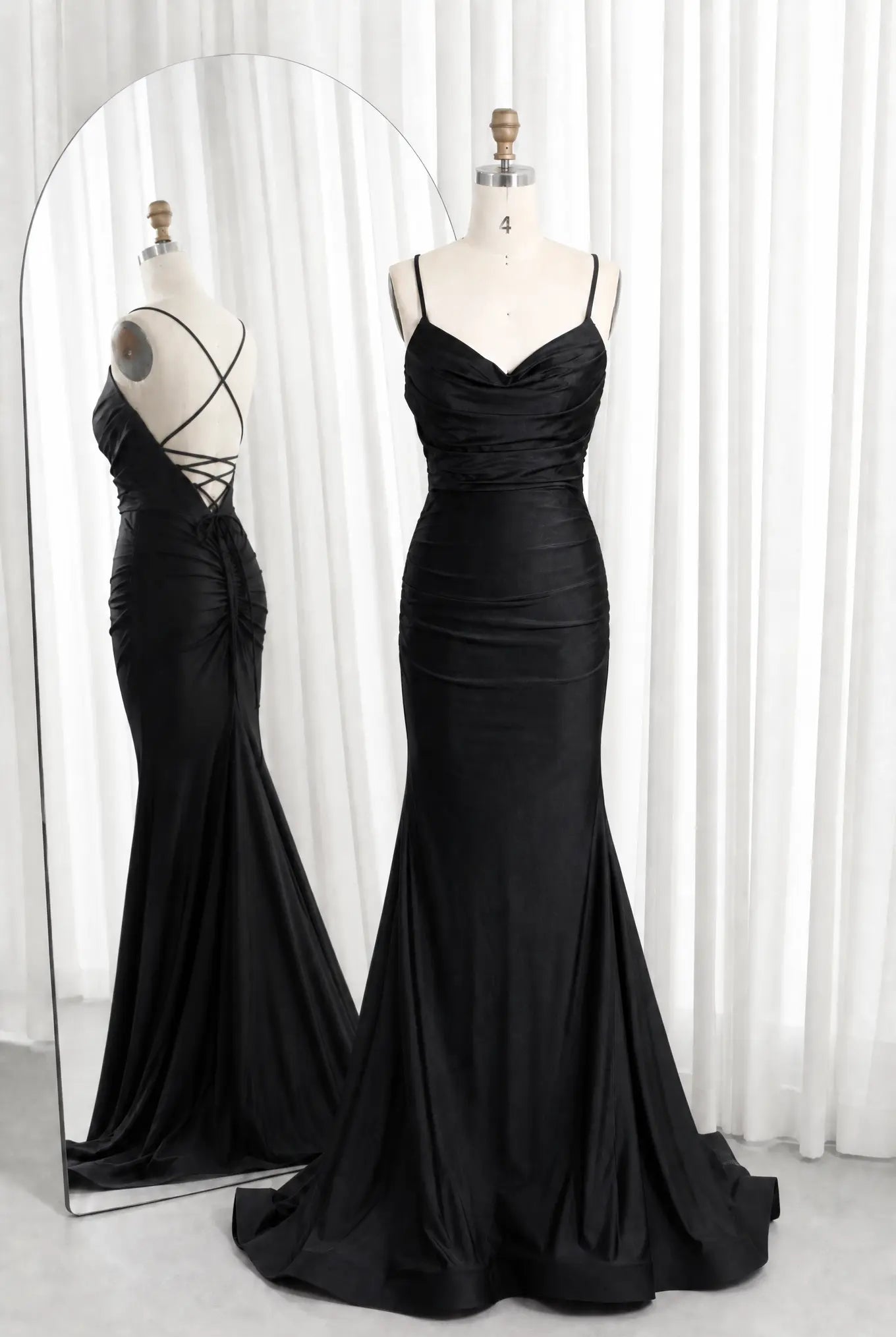 Black satin cowl-neck ruched mermaid prom dress with spaghetti straps and lace-up back.