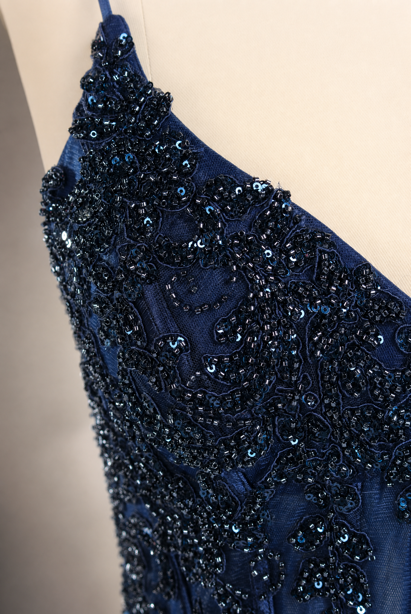 Navy beaded sequin corset-style prom dress with sparkling lace trim and draped fabric