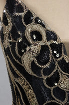 Black and gold sequin mini dress with ornate swirl and bead details, close-up