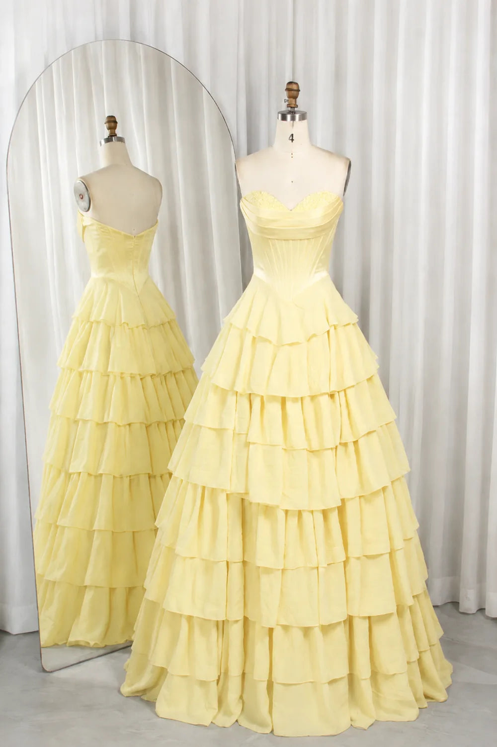 Yellow strapless tiered ruffle ball gown with corset-style bodice, layered skirt.