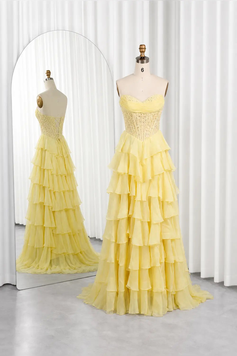 Yellow tiered ruffle strapless dress on mannequin, fitted bodice, long flowing skirt