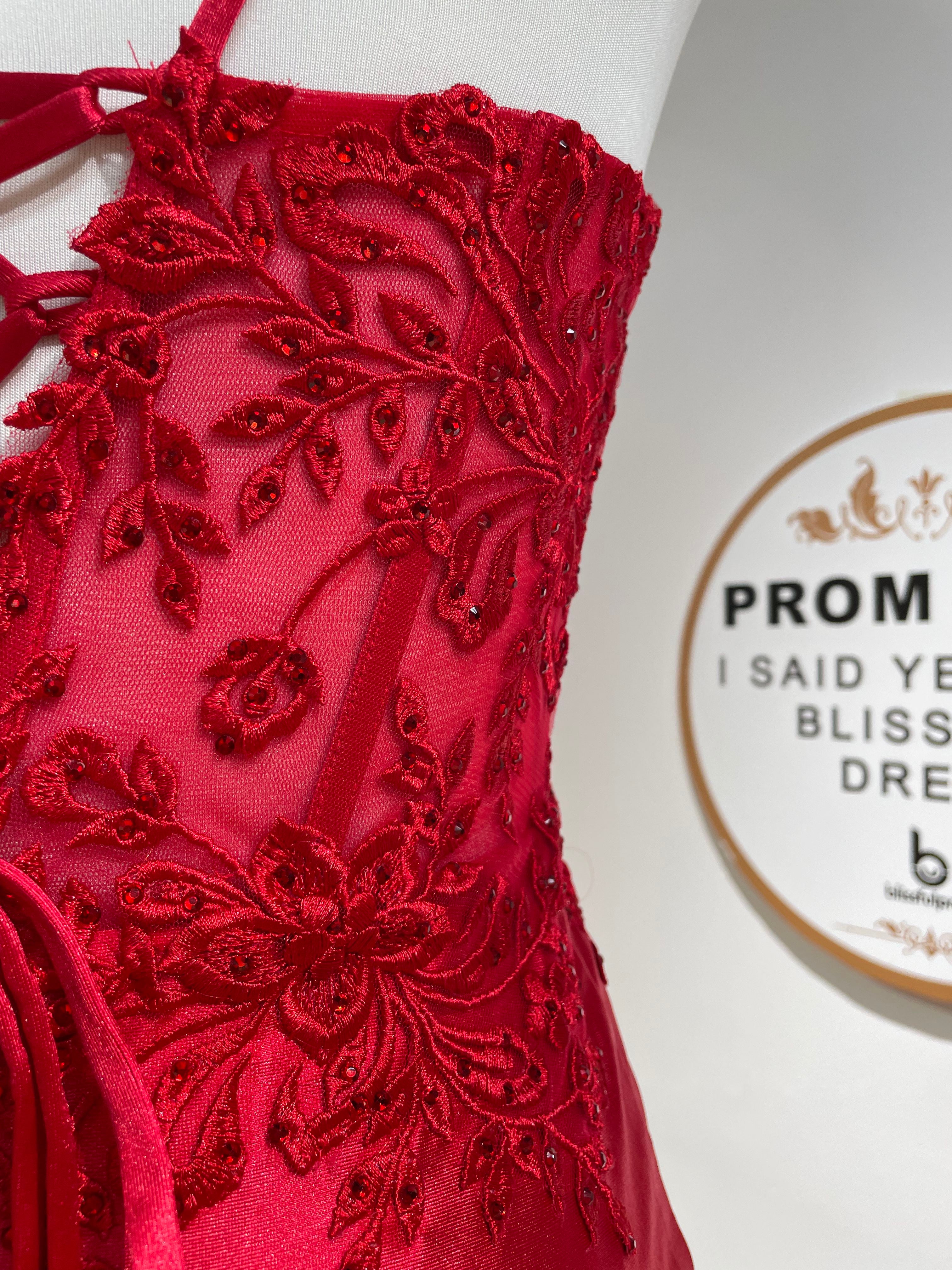 Close-up of red lace corset bodice with beaded floral detailing
