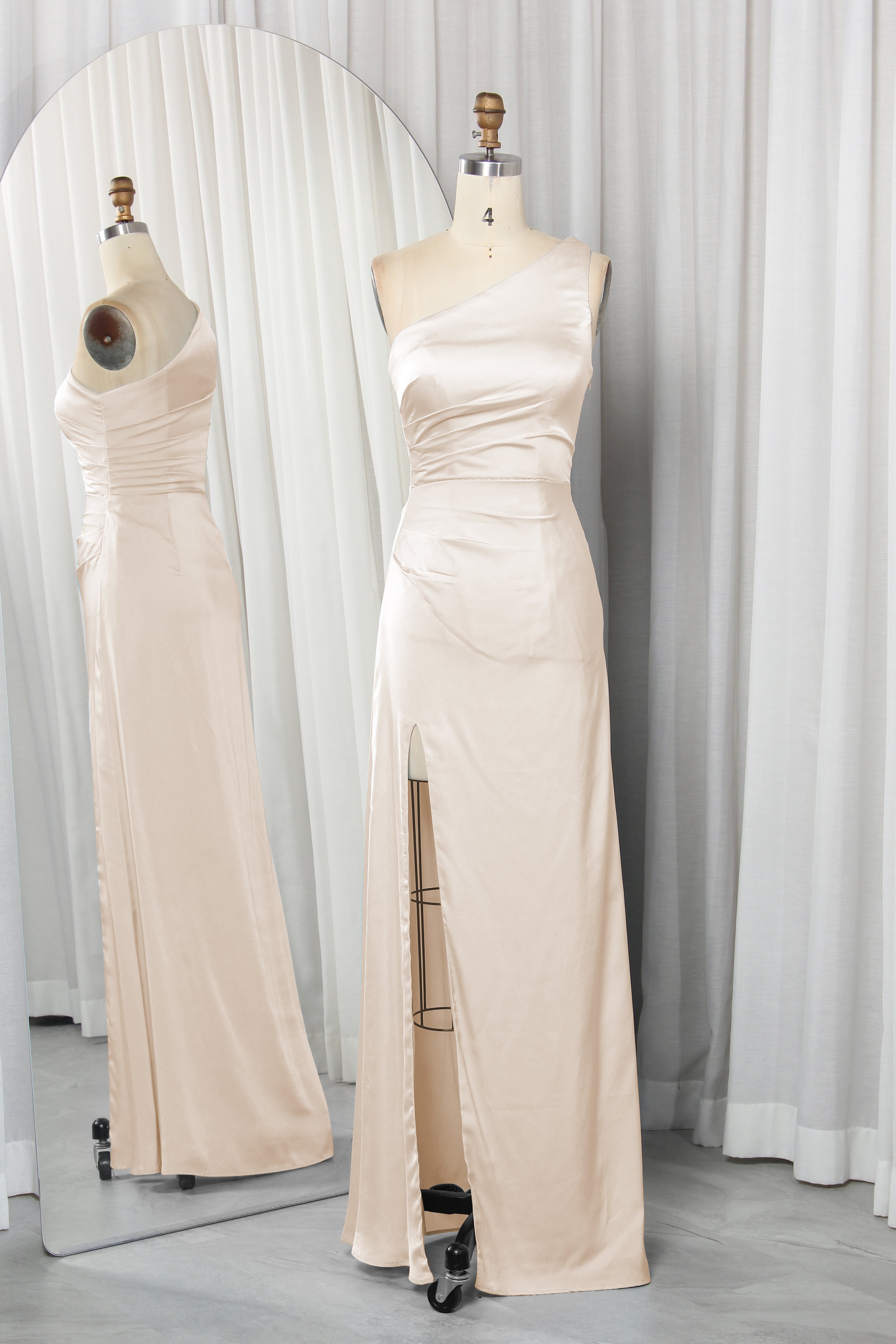 one-shoulder dress with a high slit displayed on a mannequin.