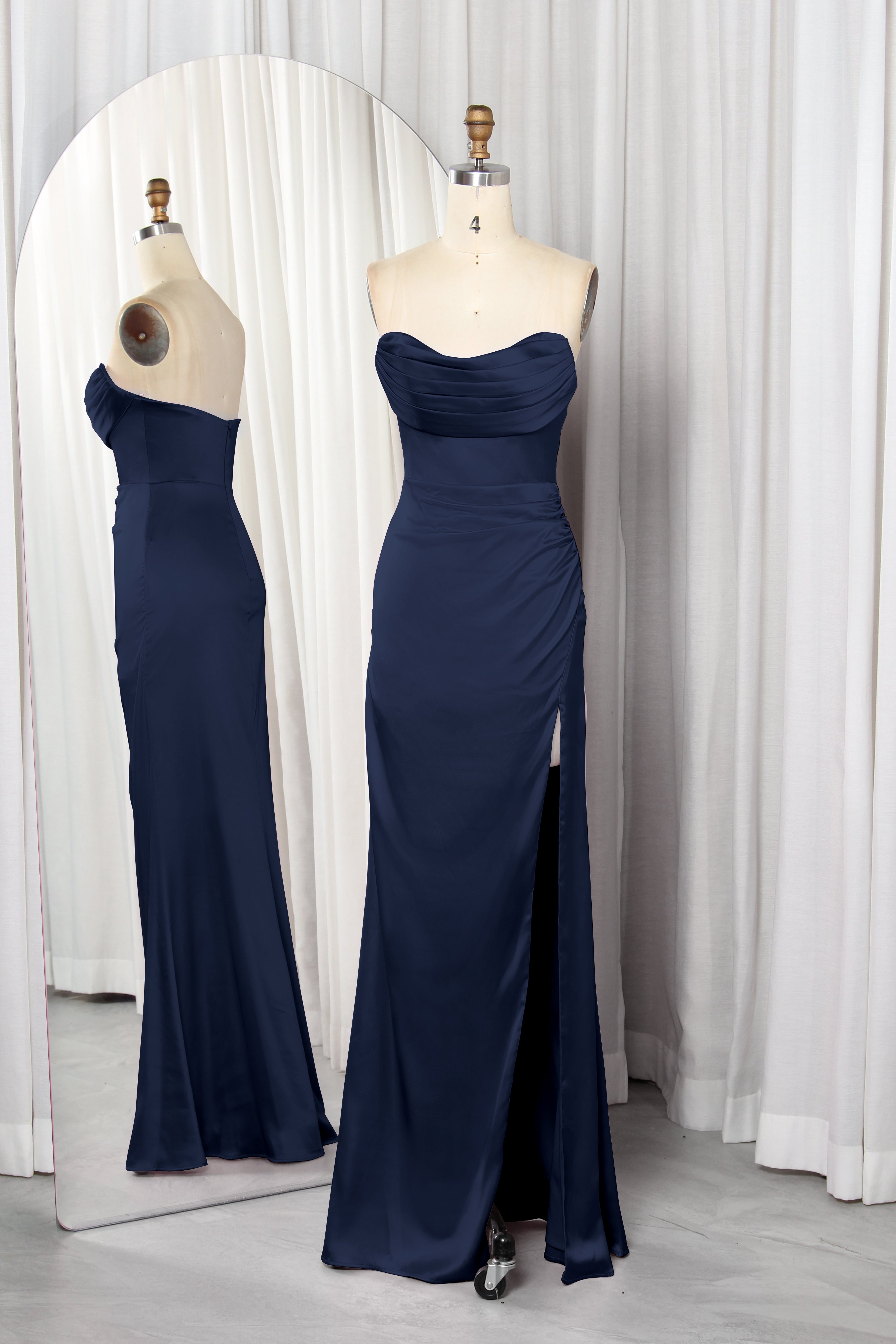 Front and back view of a vibrant red strapless satin evening gown with a ruched sweetheart neckline and high leg slit on a mannequin.