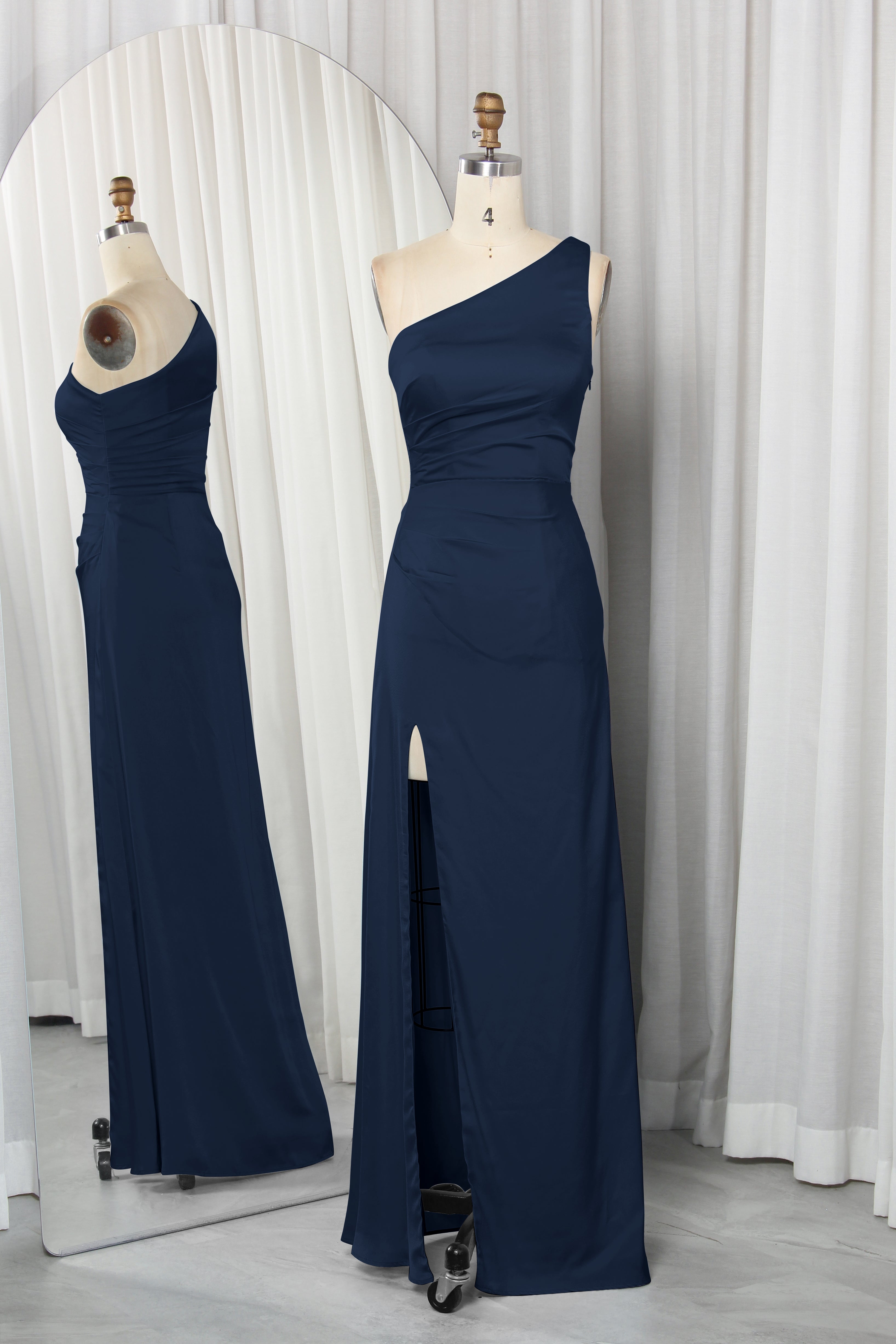 one-shoulder dress with a high slit displayed on a mannequin.