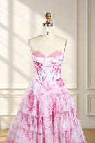 Pink-and-white floral print corset ball gown on mannequin, strapless sweetheart ruffles