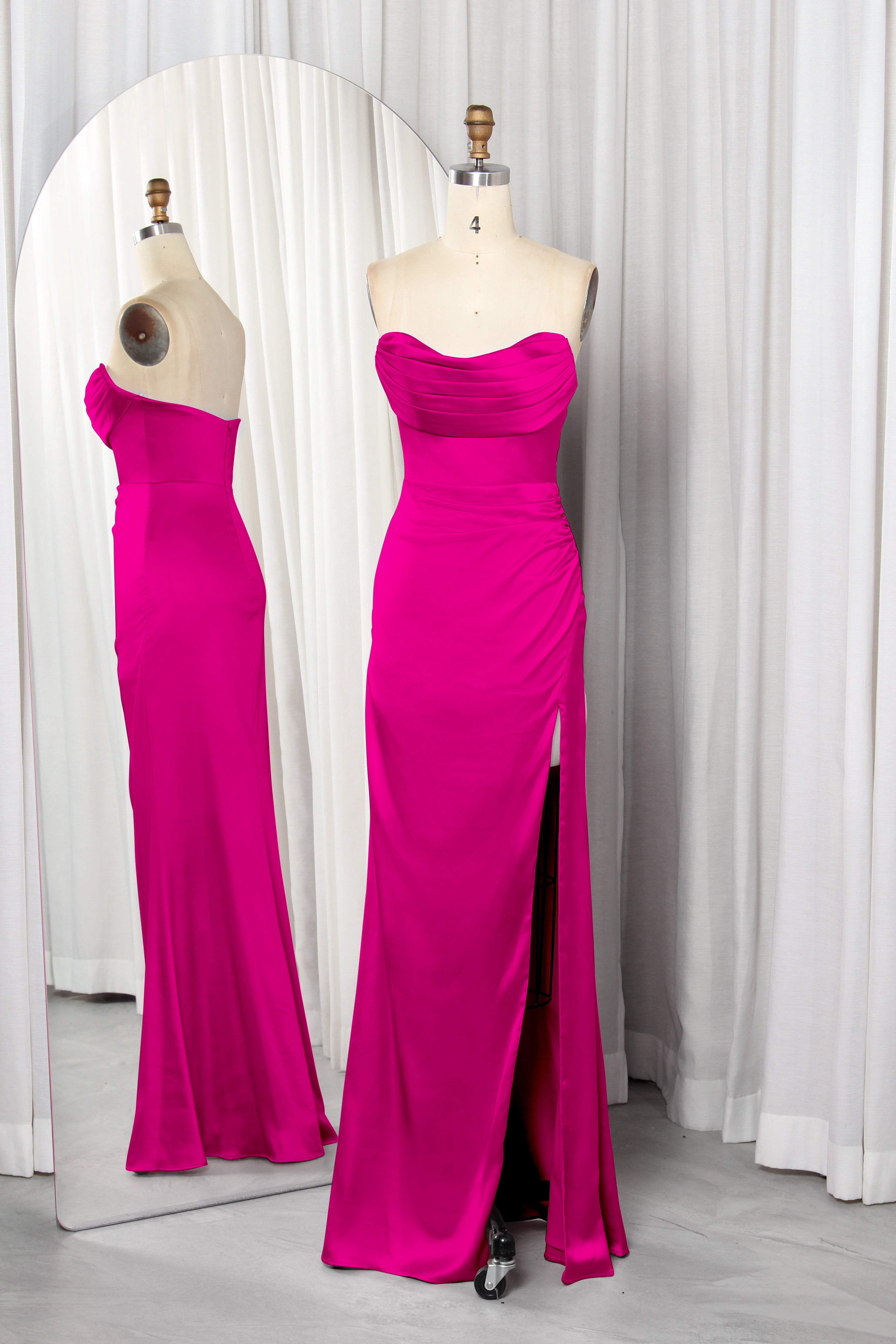 Front and back view of a vibrant red strapless satin evening gown with a ruched sweetheart neckline and high leg slit on a mannequin.