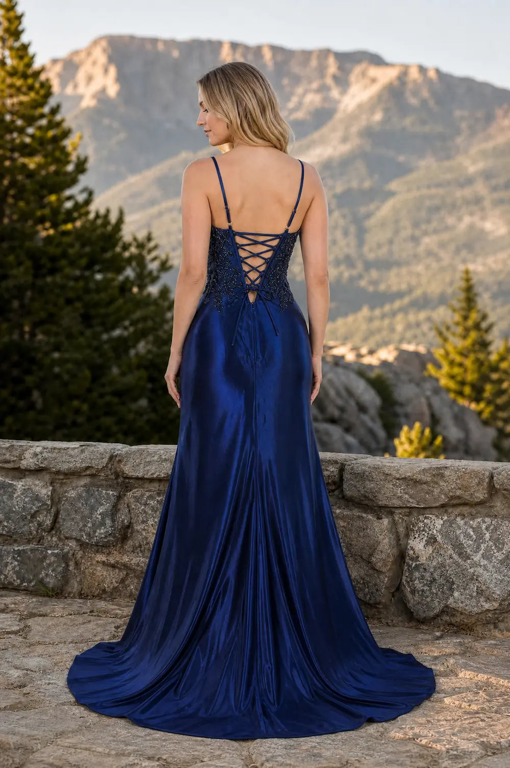 Navy open-back sequin gown with crisscross straps and sweeping satin train