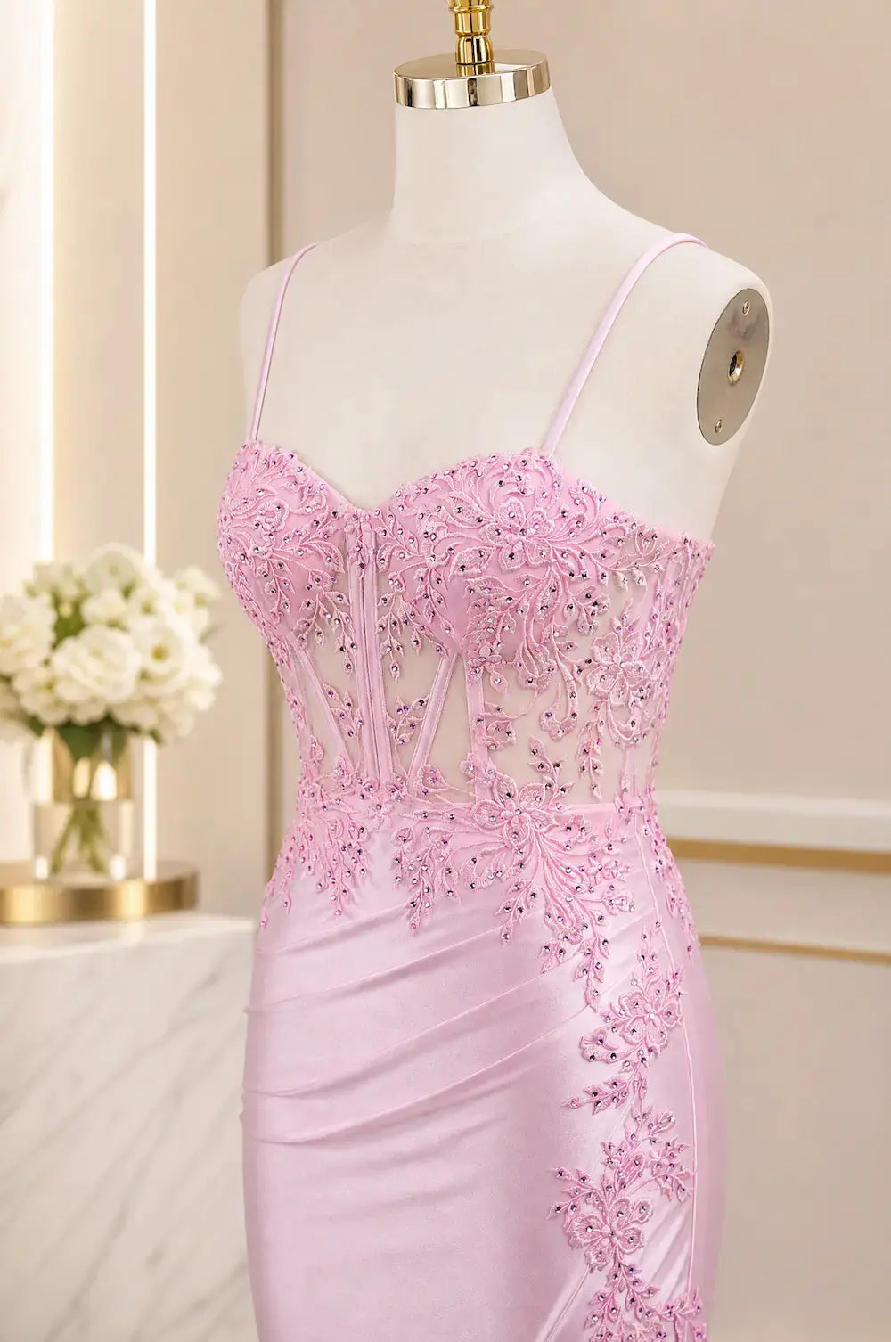 Pink corset evening dress on mannequin with spaghetti straps and beadwork
