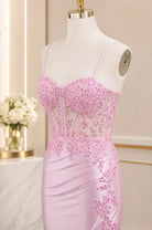 Pink corset evening dress on mannequin with spaghetti straps and beadwork