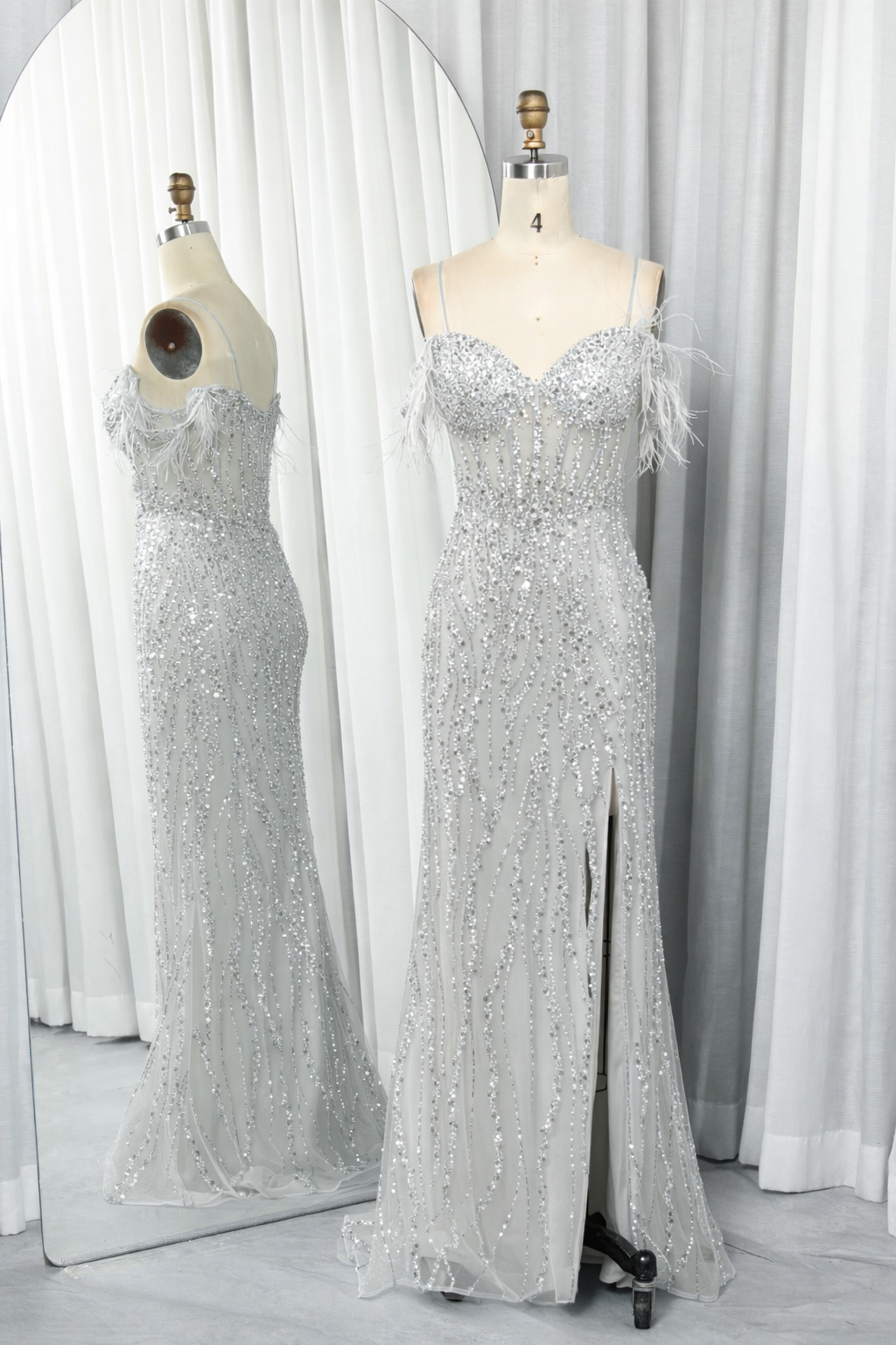 Silver sequin prom dress with spaghetti straps, V neckline, feather trim, and side slit