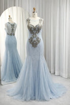 Sky blue lace appliqué illusion neckline gown on mannequin with fitted bodice and tulle skirt