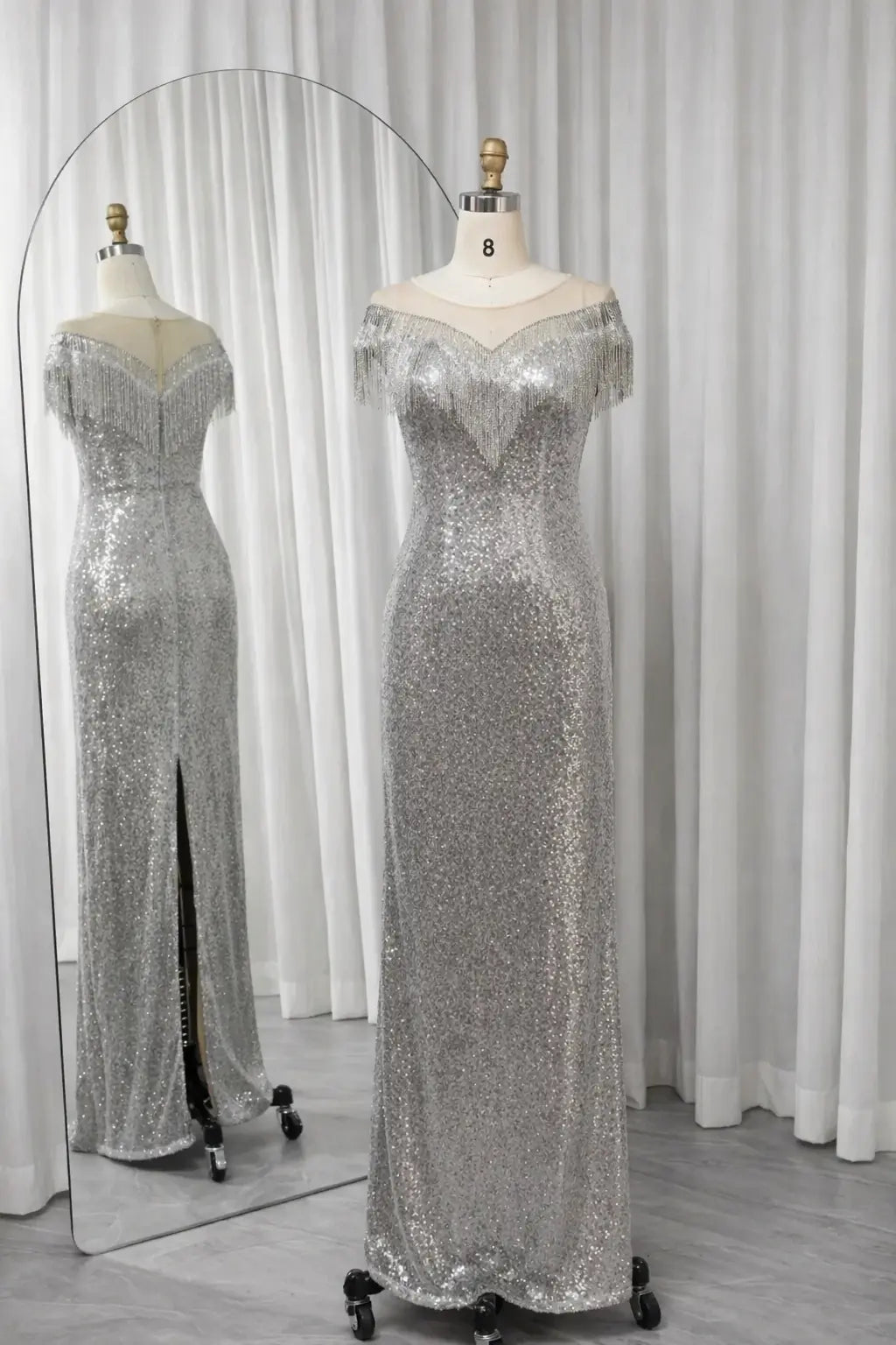 Silver sequin gown with off-shoulder neckline, fringe sleeves, and side slit