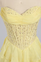 Yellow plus-size tiered ruffle gown with beaded corset bodice and sweetheart neckline