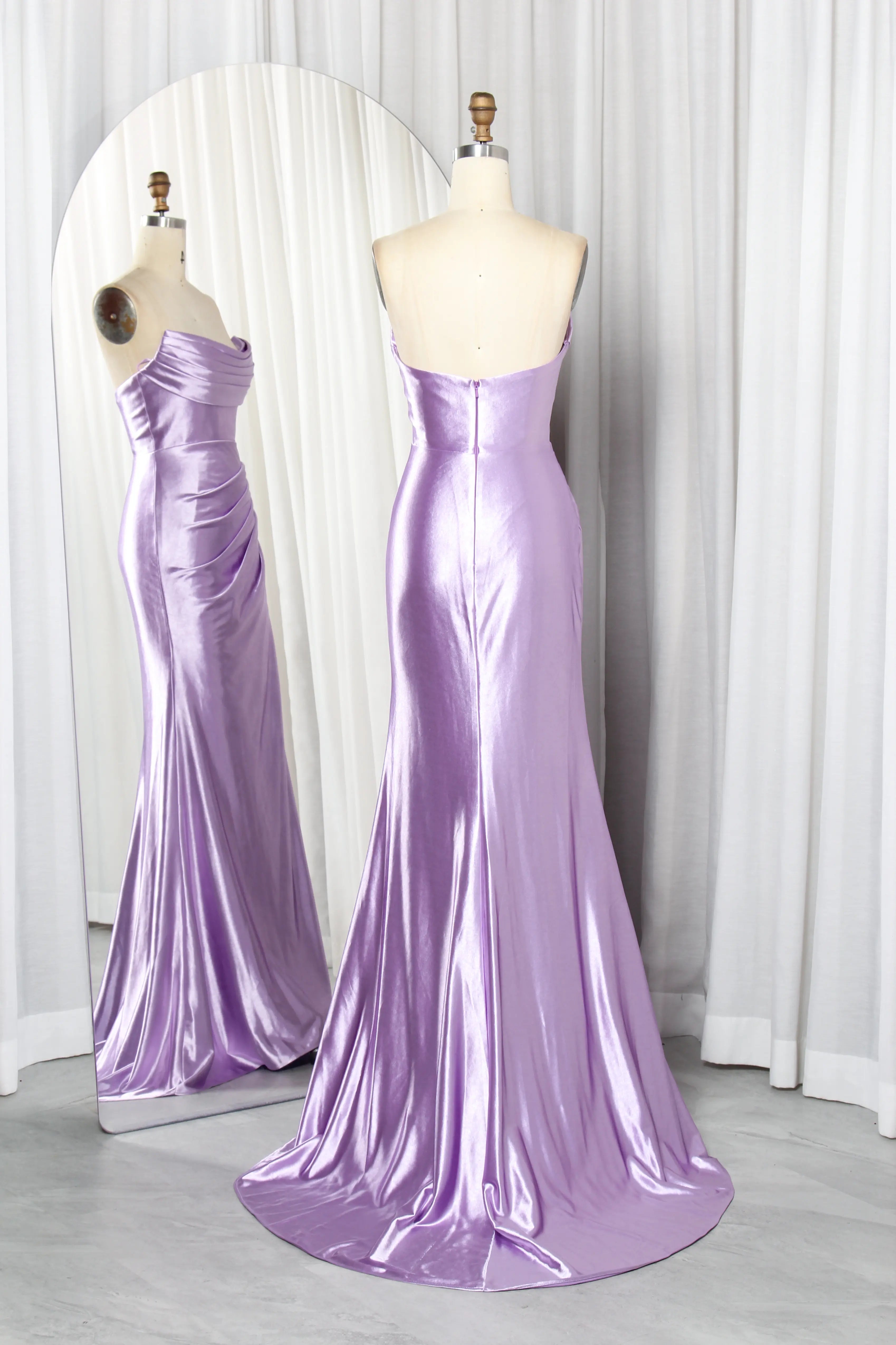 Lilac strapless satin mermaid prom gown on mannequin, draped bodice and long flared skirt