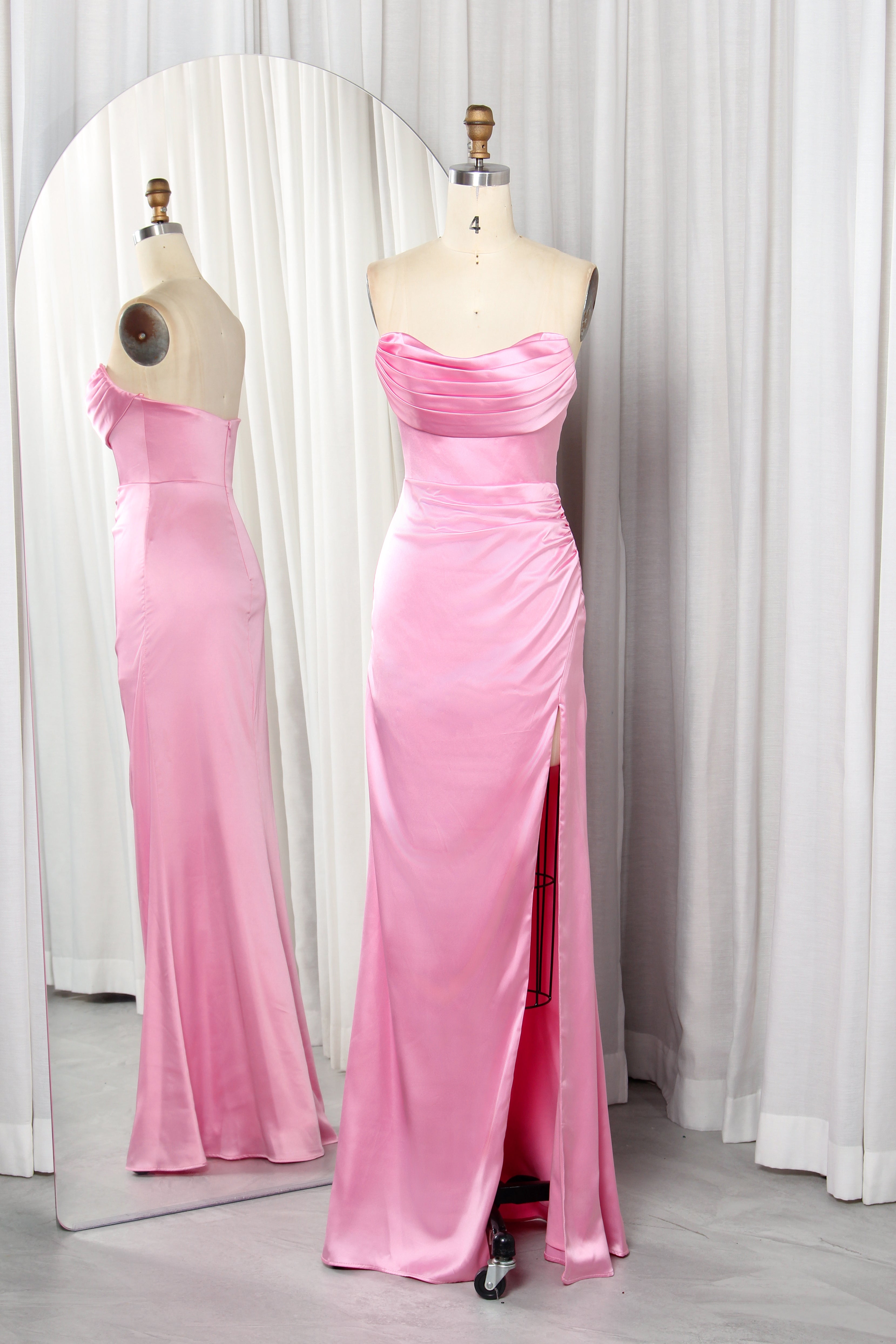 Front and back view of a vibrant red strapless satin evening gown with a ruched sweetheart neckline and high leg slit on a mannequin.