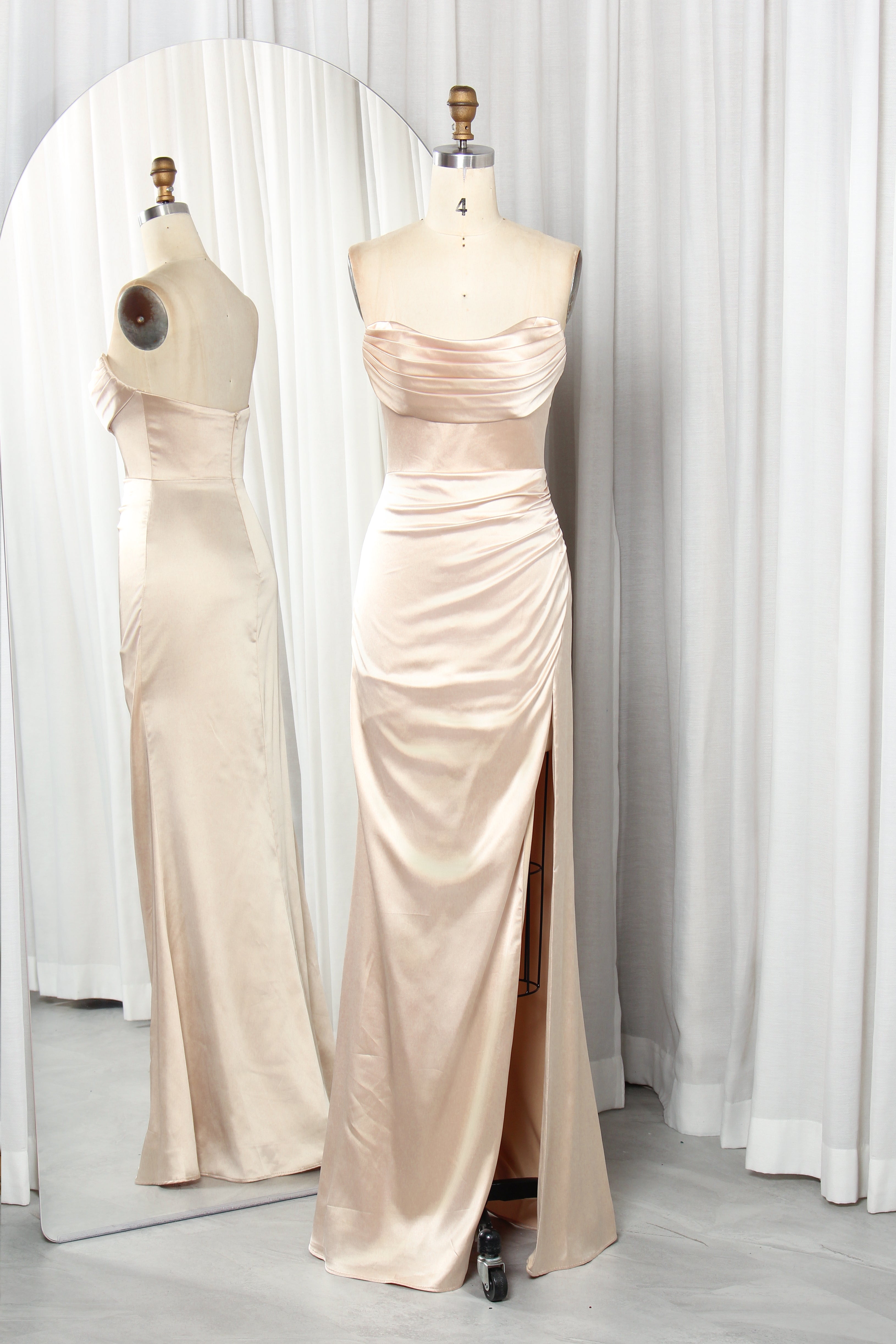 Front and back view of a vibrant red strapless satin evening gown with a ruched sweetheart neckline and high leg slit on a mannequin.