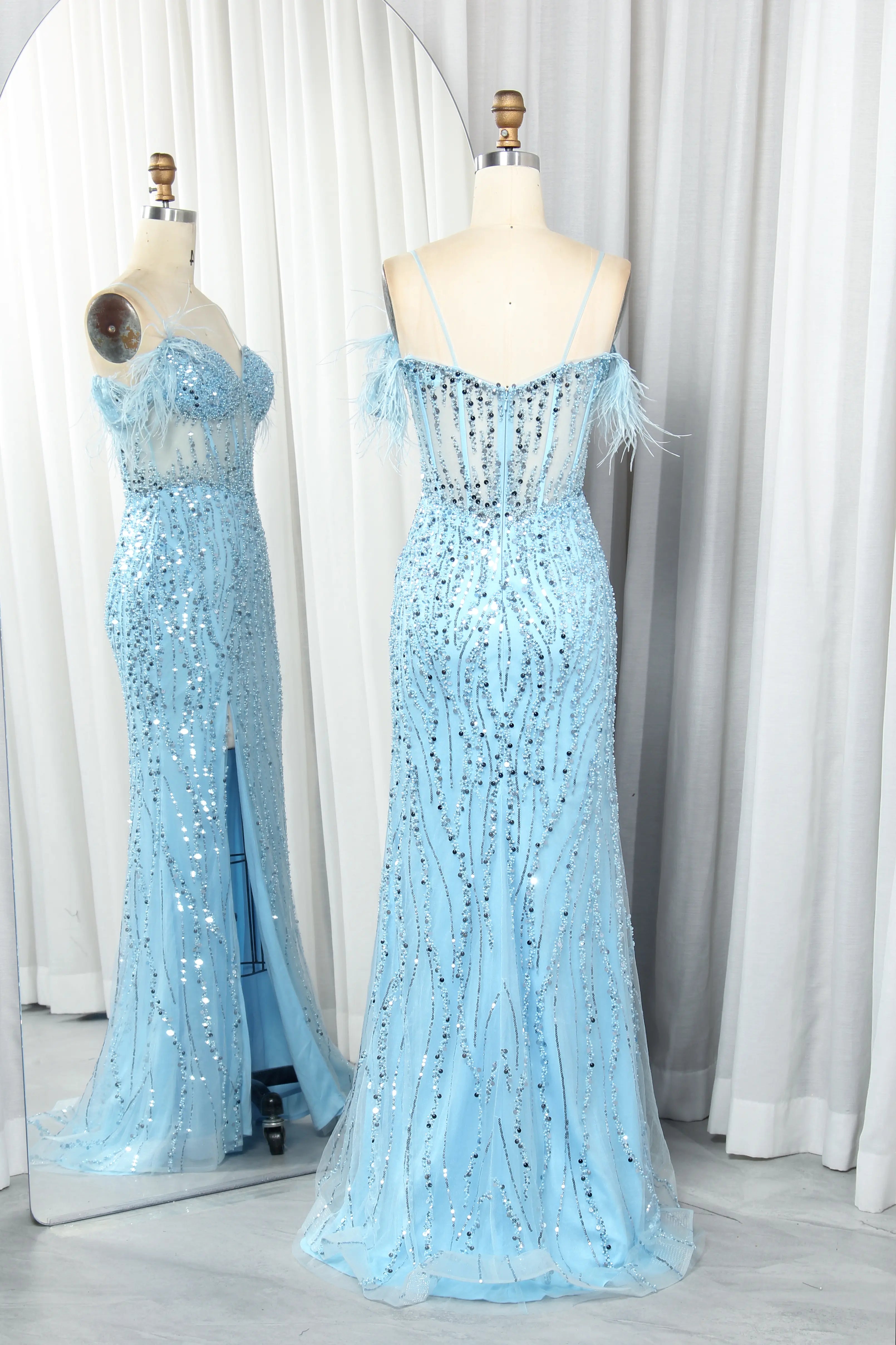 Sky blue sequin prom dress on mannequin with feather off-shoulder straps and slit
