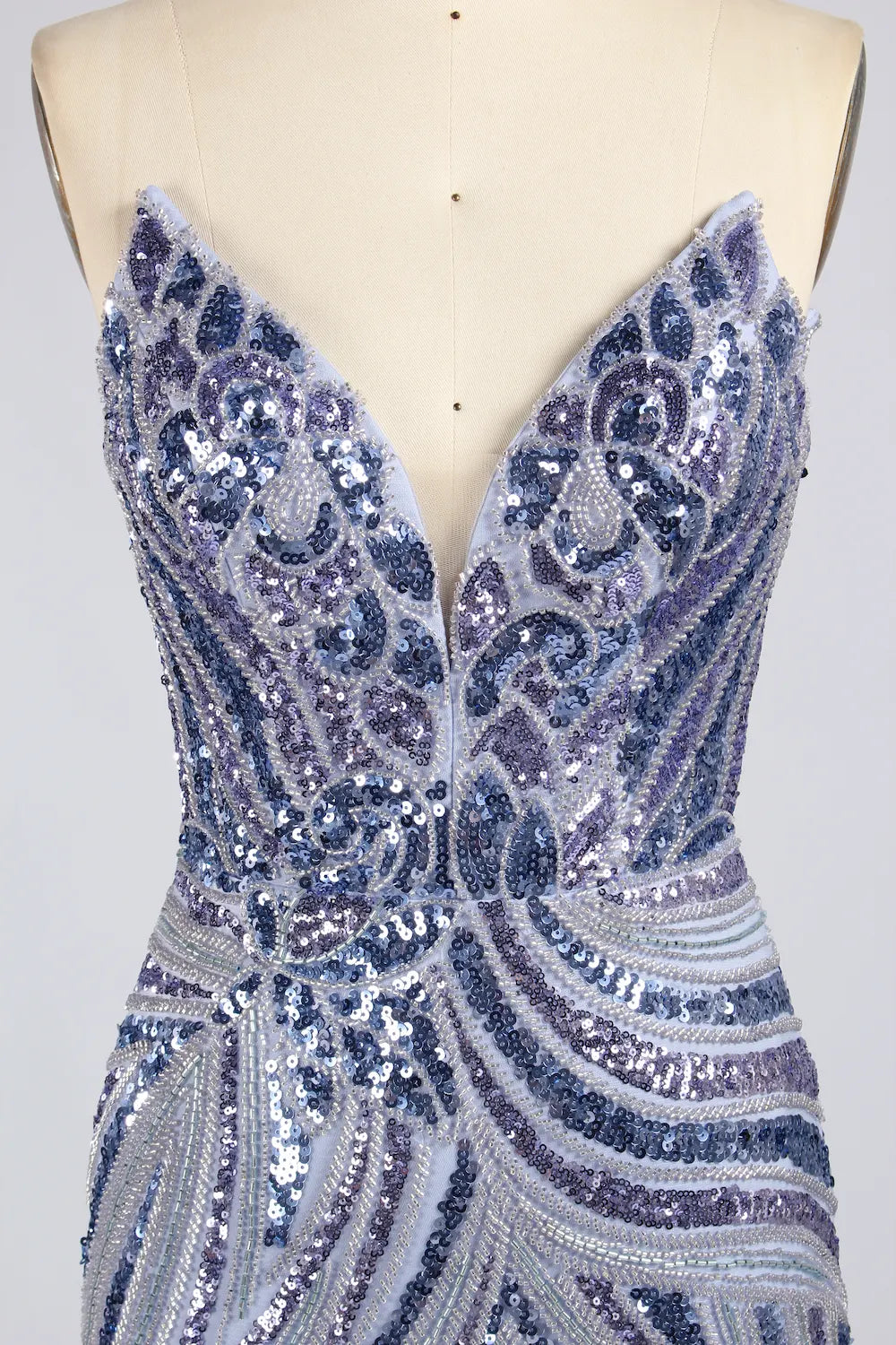 Silver sequin mini dress on mannequin, deep V-neck and fitted skirt