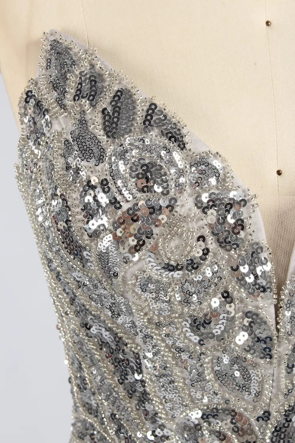Silver sequin fabric panel with swirling bead and rhinestone pattern