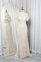 Champagne mermaid gown with floral appliques, fitted waist, and short ruffle sleeves