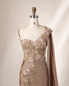 Champagne one-shoulder satin gown with detailed 3D floral appliqués and draped sleeve