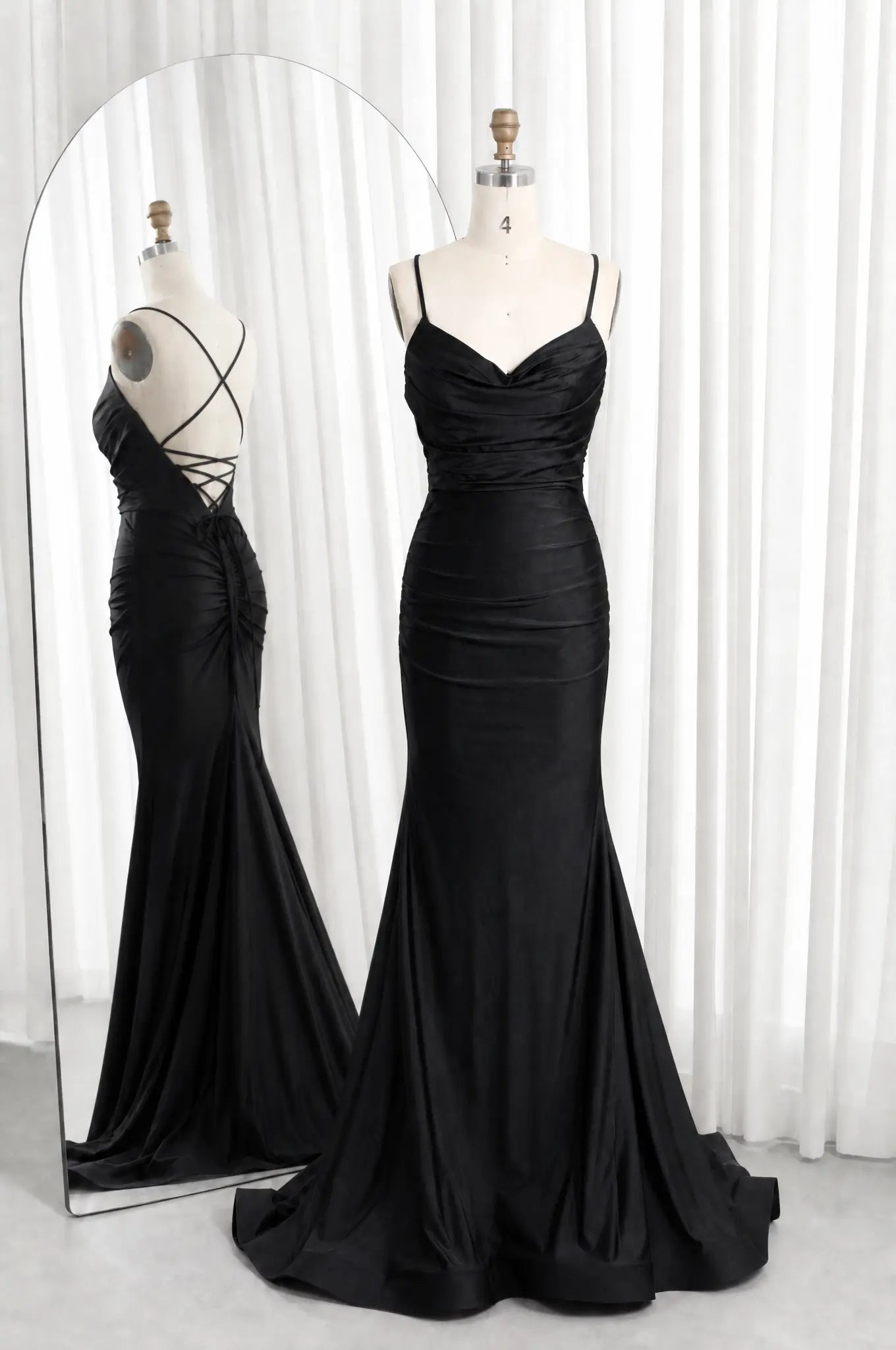 Black satin cowl-neck ruched mermaid prom dress with spaghetti straps and lace-up back.