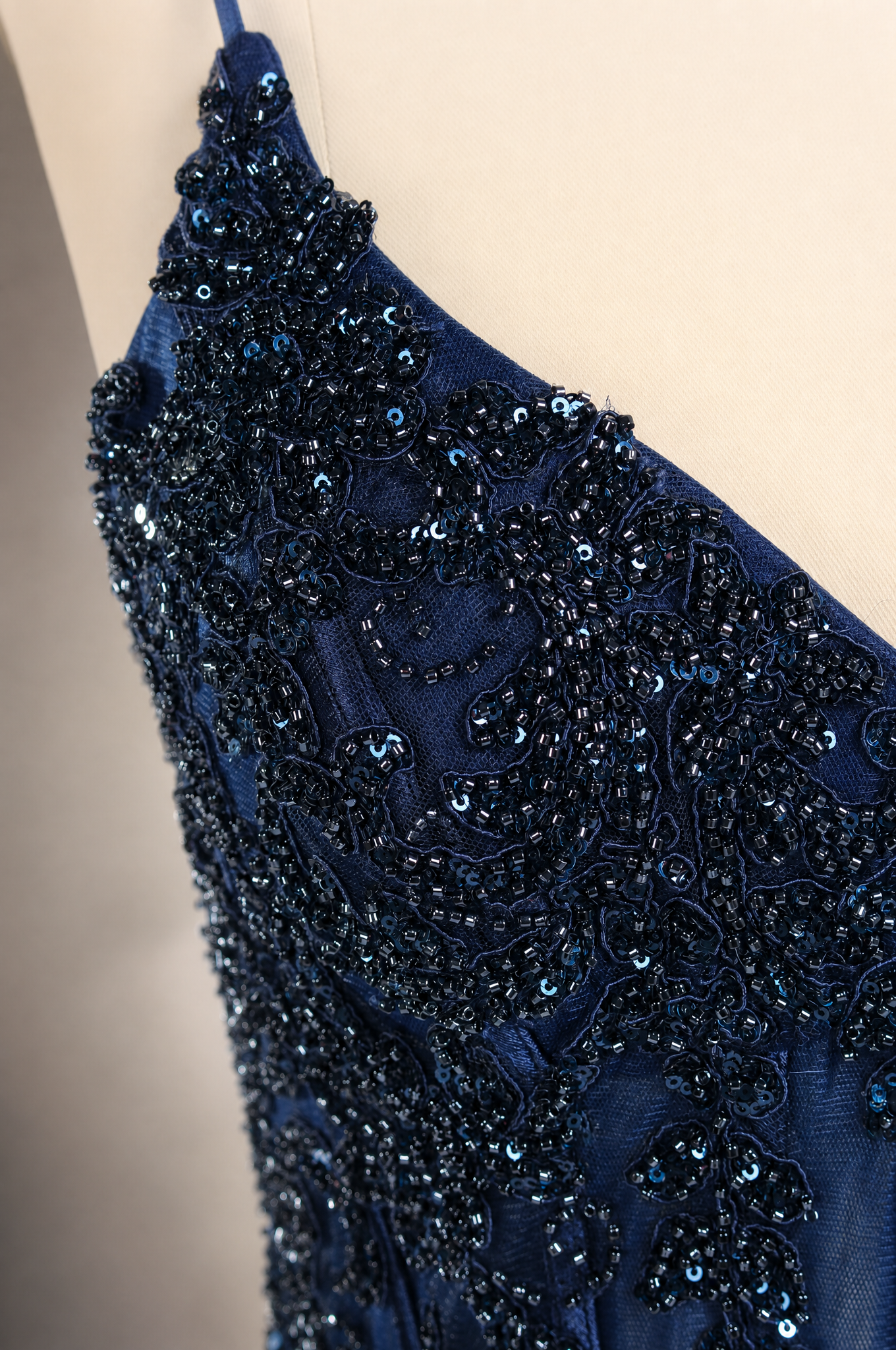 Navy beaded sequin corset-style prom dress with sparkling lace trim and draped fabric